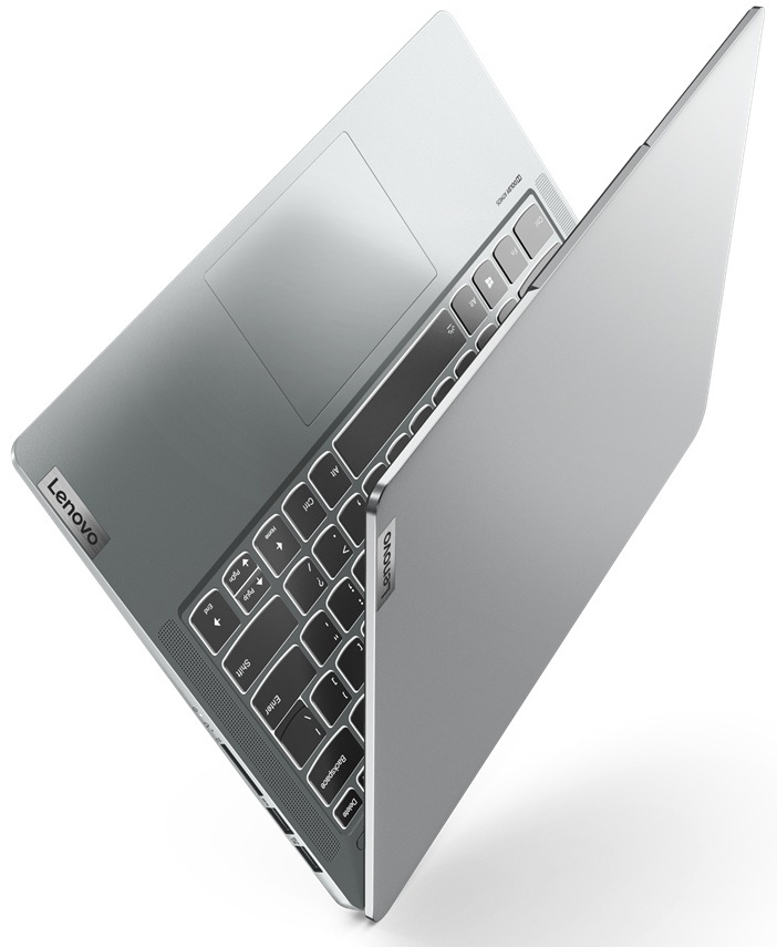 Un ordinateur portable gris, incliné sur une surface blanche.