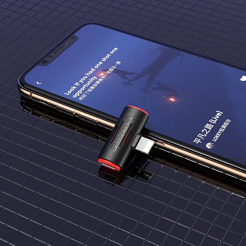 Egy fekete-piros Lightning–3,5 mm-es audioadapter egy telefon képernyőjén. A háttér sötét.