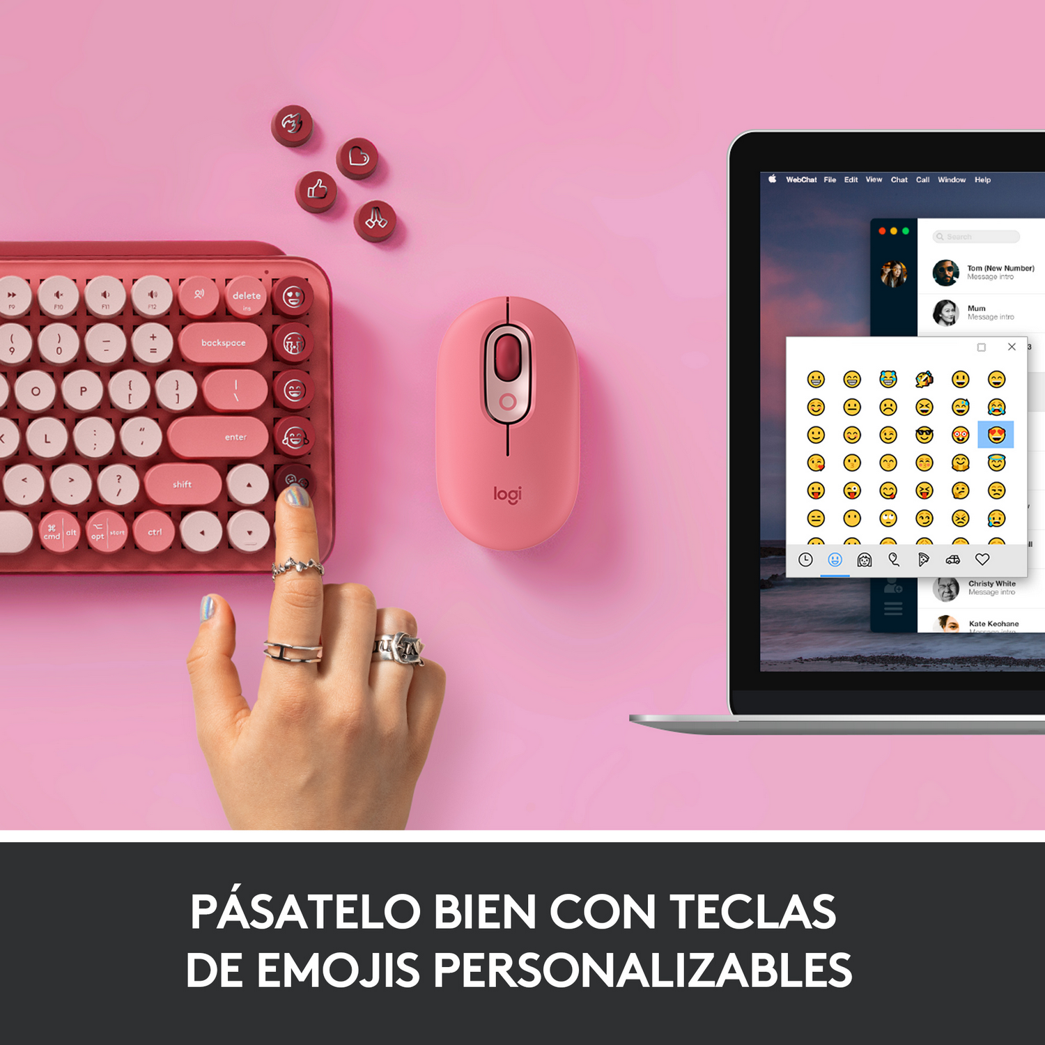 Un teclado y un ratón rosas con un portátil que muestra una ventana de chat de emojis.