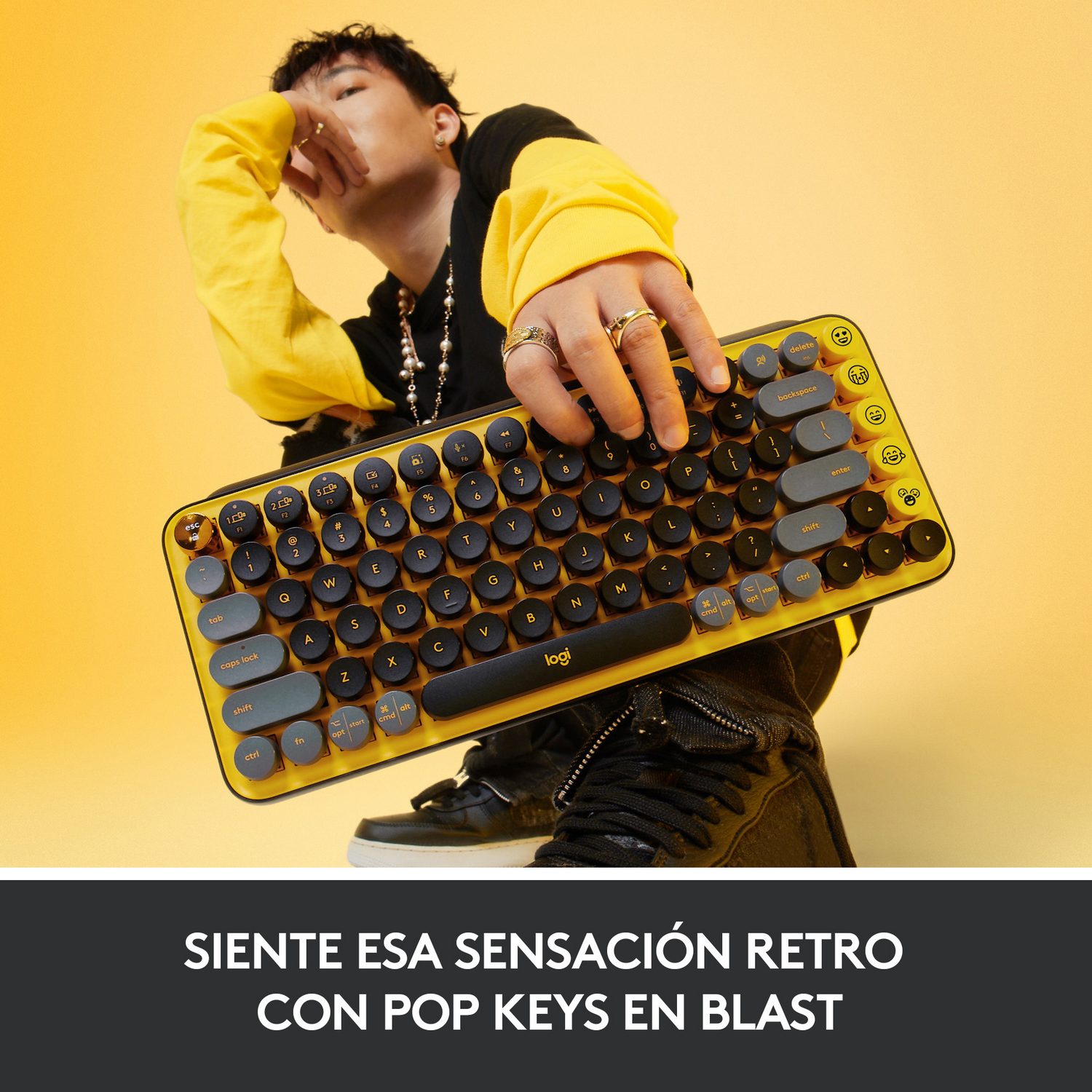 Un hombre sosteniendo un teclado amarillo y gris. La imagen también tiene un lema en español.