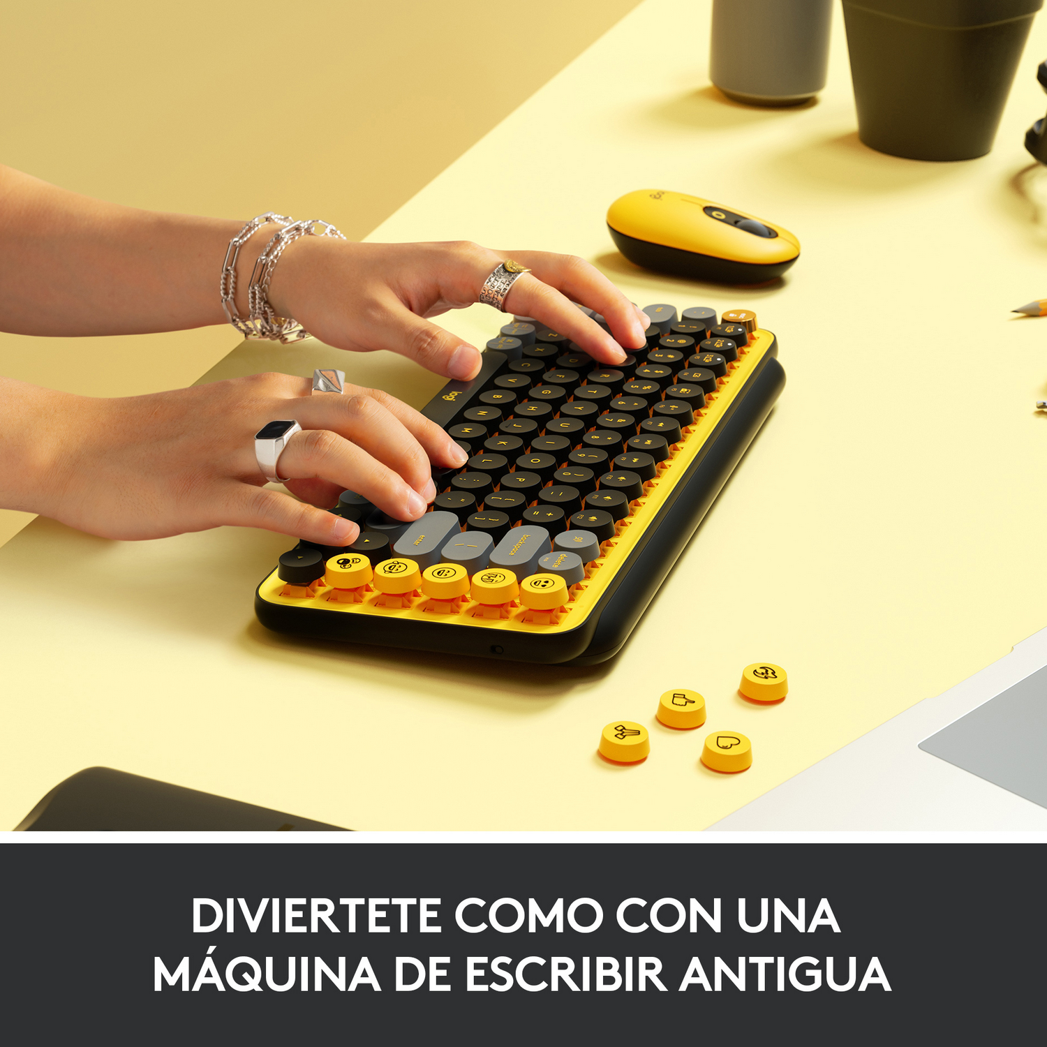 Manos escribiendo en un teclado amarillo y negro. Texto: Disfrútalo como una máquina de escribir antigua.