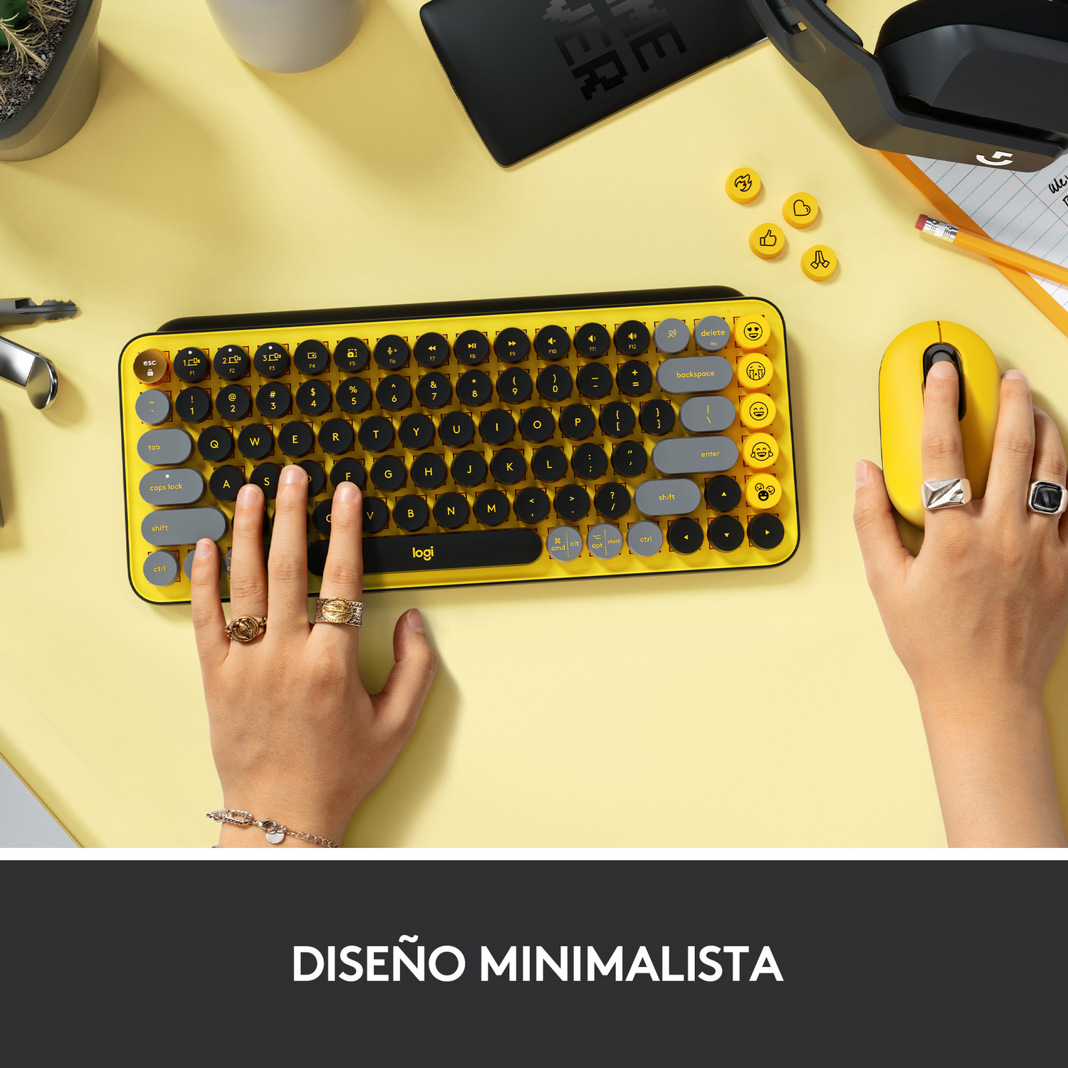 Teclado y ratón amarillos sobre una superficie amarilla. Manos sobre el teclado.