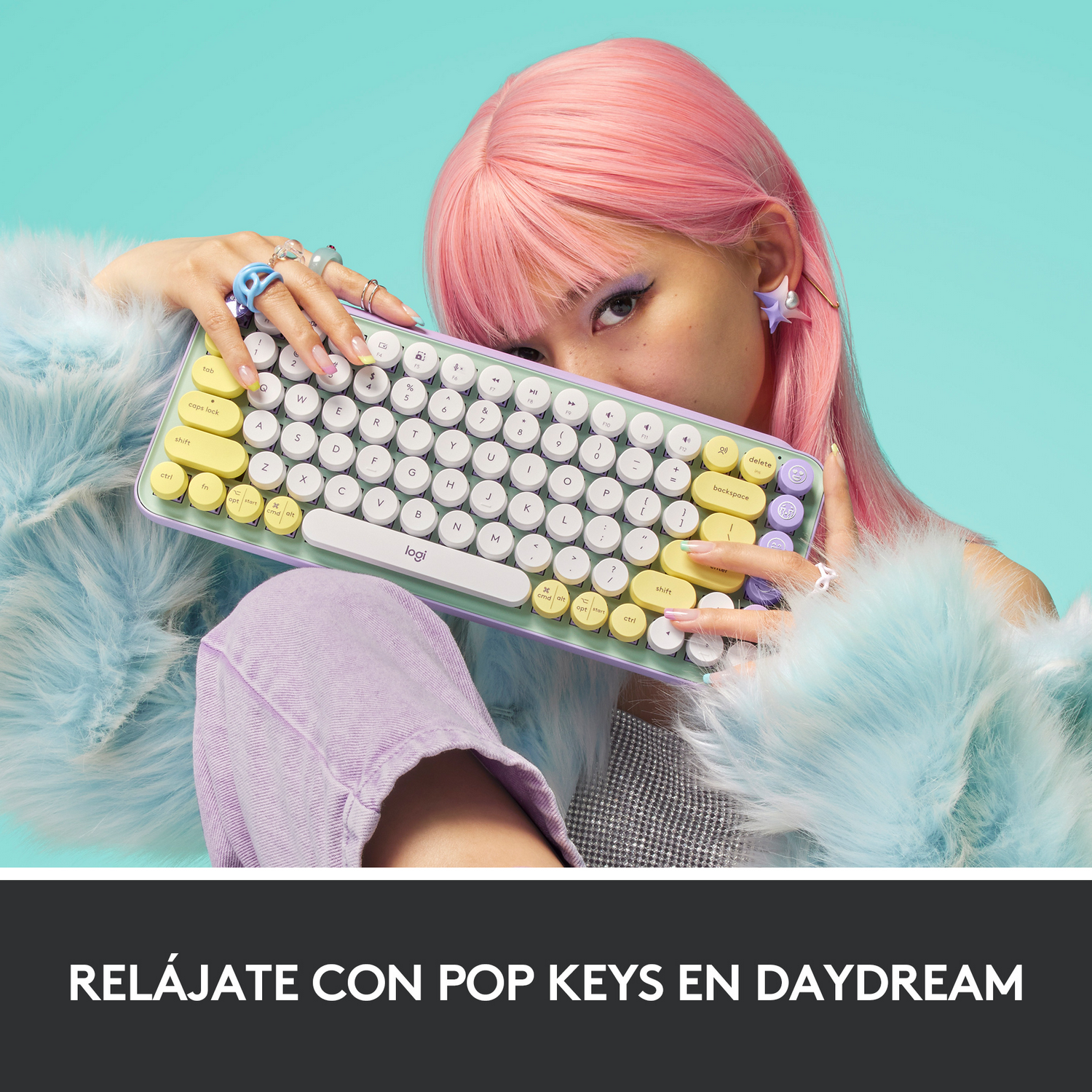 Una persona sosteniendo un teclado con una persona de pelo rosa en el fondo y un fondo azul.