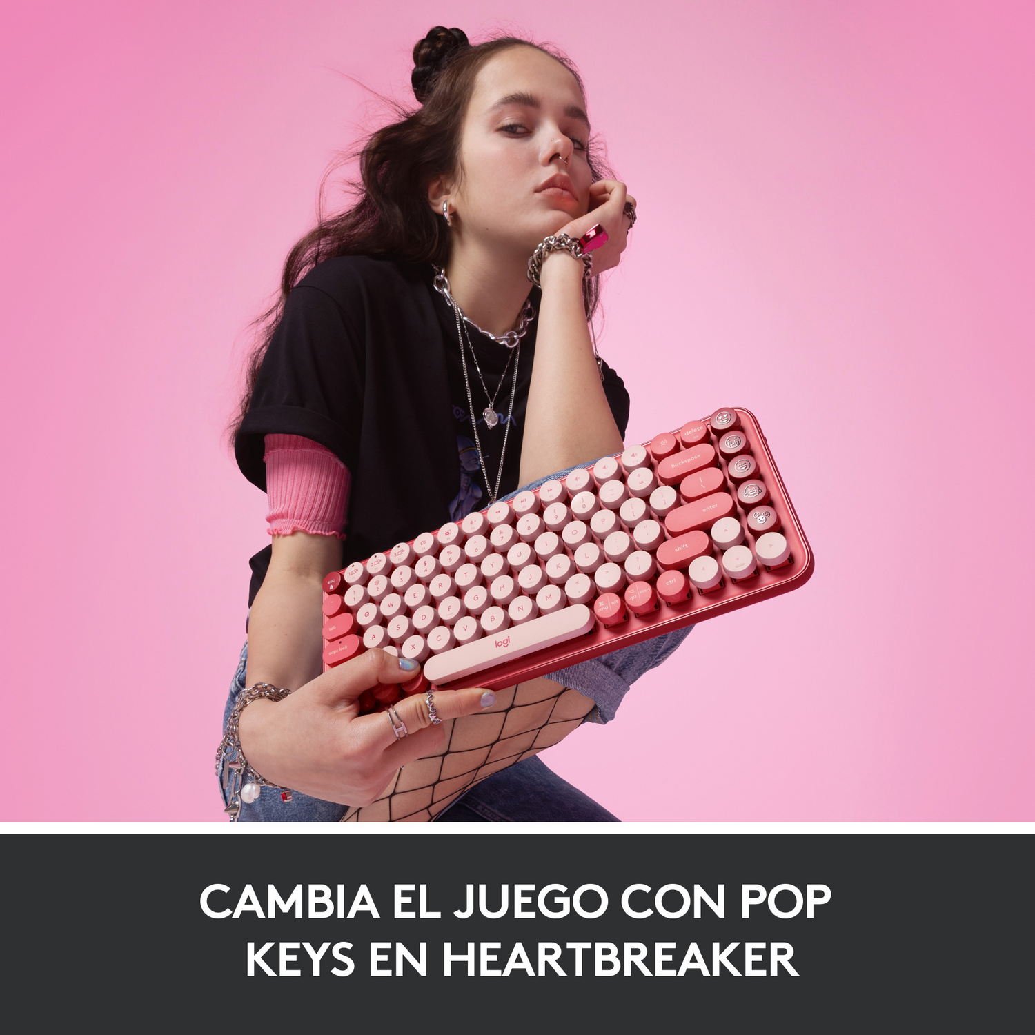 Una mujer sostiene un teclado rojo y rosa y mira a la cámara.