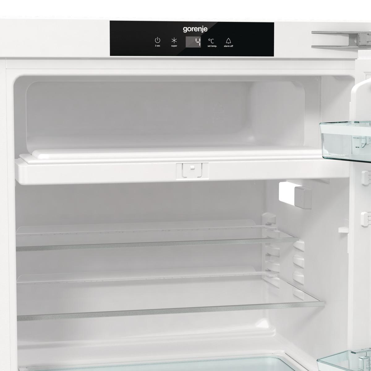 Offener weißer Kühlschrankinnenraum mit Regalen. Das Gorenje-Logo ist auf der oberen Platte sichtbar.