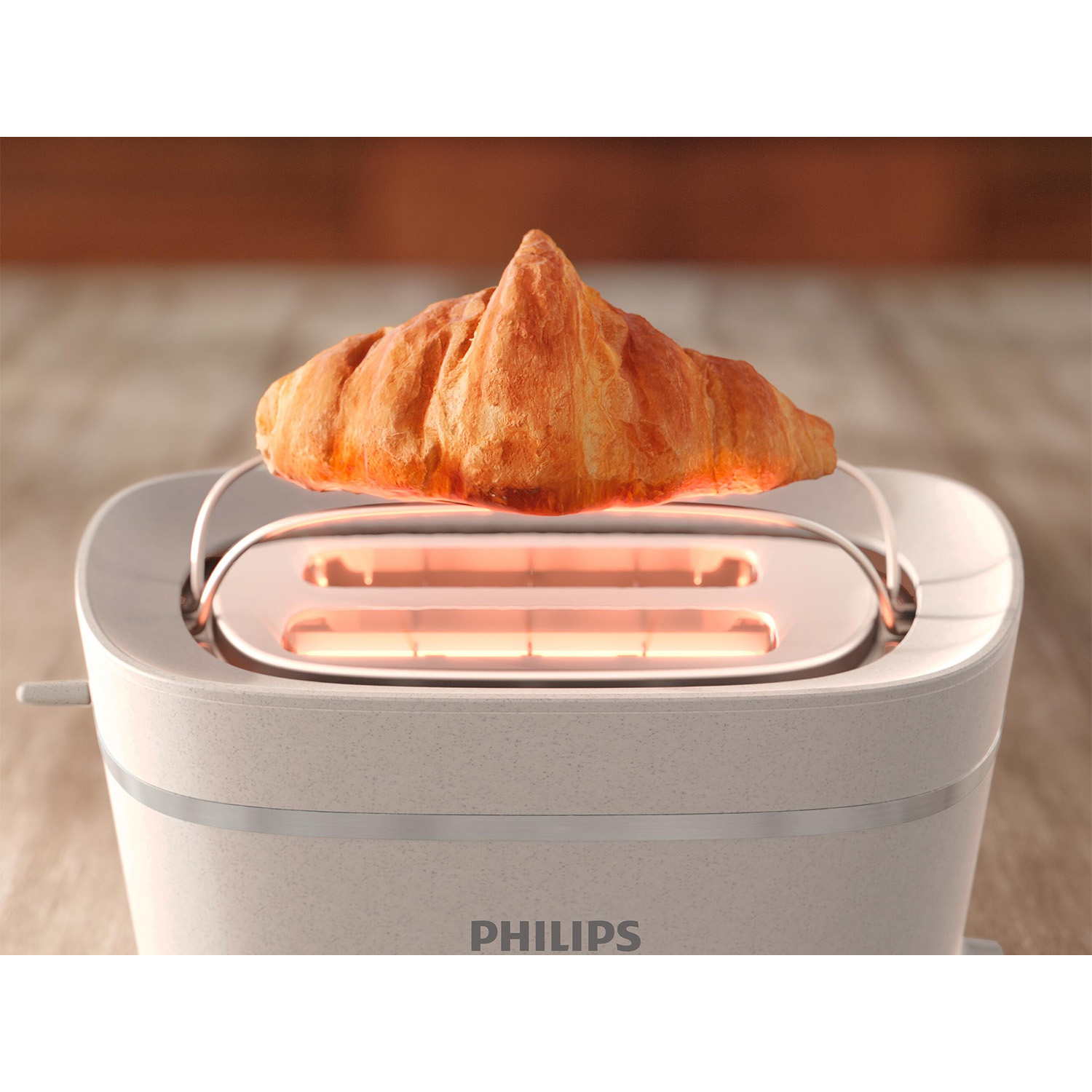 Tostapane con croissant all'interno. Chiaro, marca Philips. Sfondo in legno.