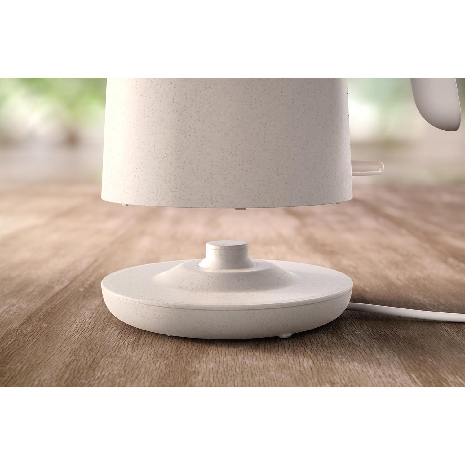 Primo piano della base di un bollitore elettrico bianco su una superficie di legno.
