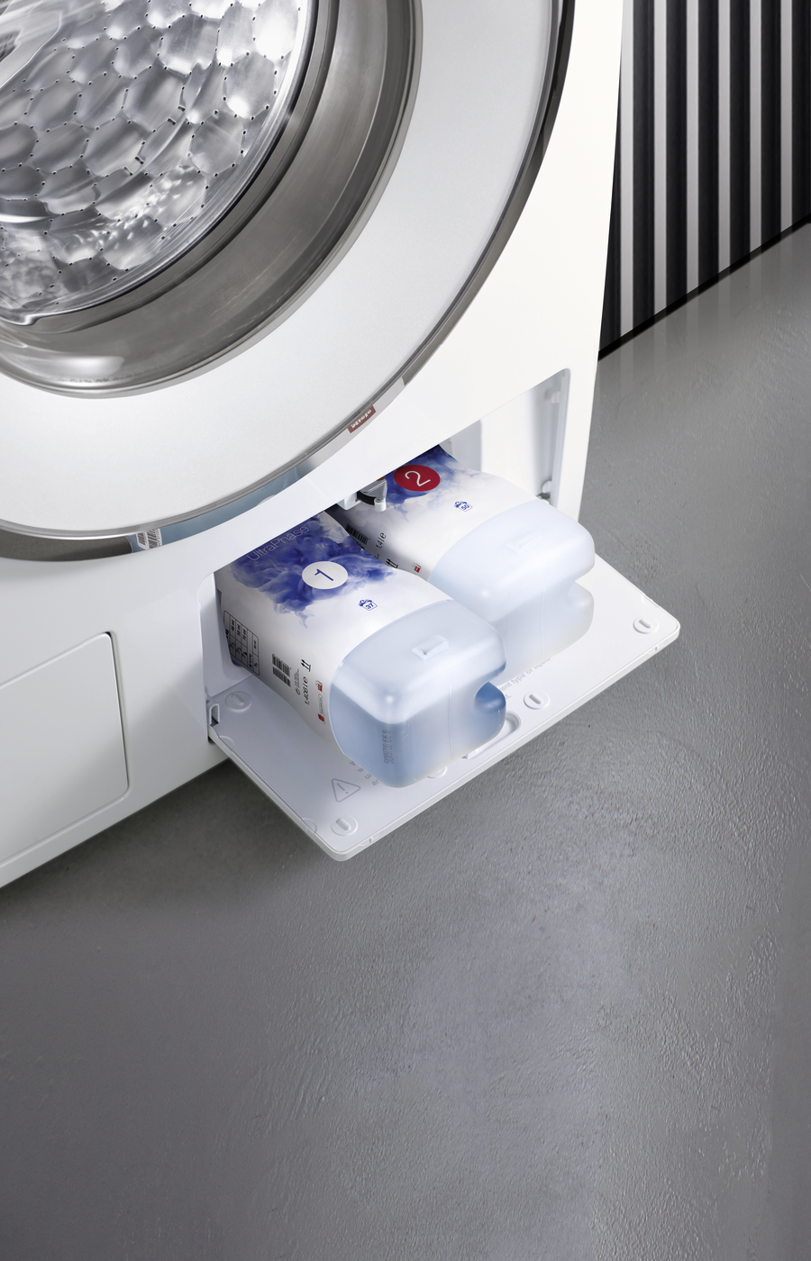 Eine Waschmaschine mit geöffneter Schublade, die zwei Waschmittelbehälter zeigt.