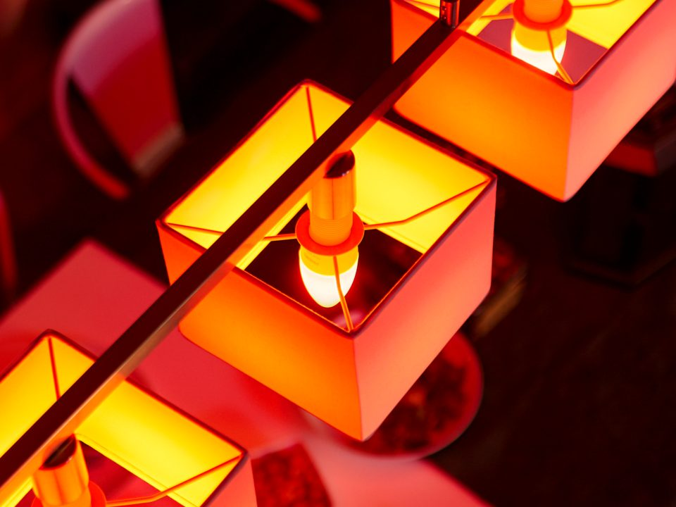 Vue aérienne de trois lampes carrées orange éclairées avec des ampoules visibles.