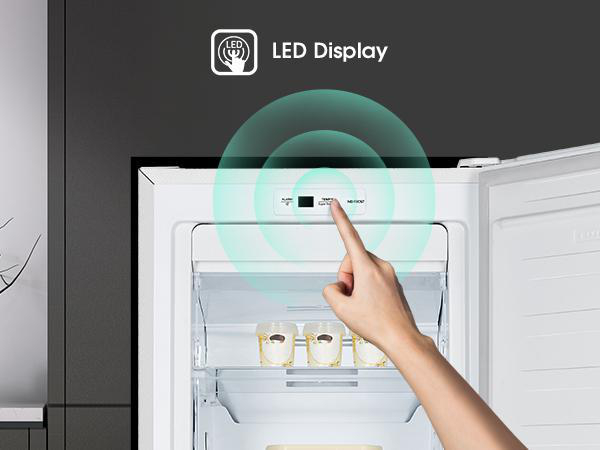 Hand berührt eine Kühlschranktaste. Die Taste ist beleuchtet, mit einer LED-Anzeige.