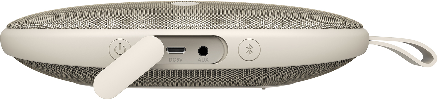 Side view of a beige portable speaker with a flap open. Ports and buttons visible.