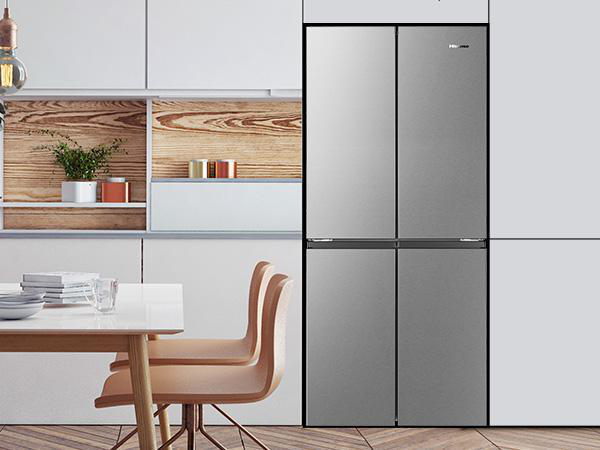 Küche mit weißen Schränken, Holzregal und einem Hisense-Kühlschrank aus Edelstahl.