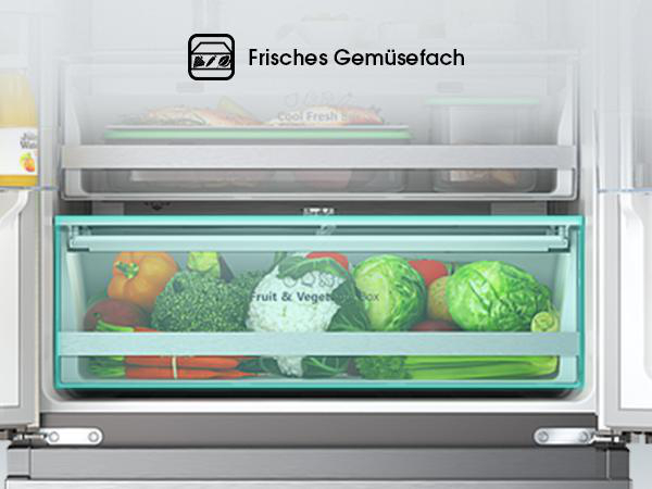Kühlschrankinnenraum mit Gemüseschublade voller Produkte, darunter Salat, Kohl und Paprika, sowie ein Regal darüber.