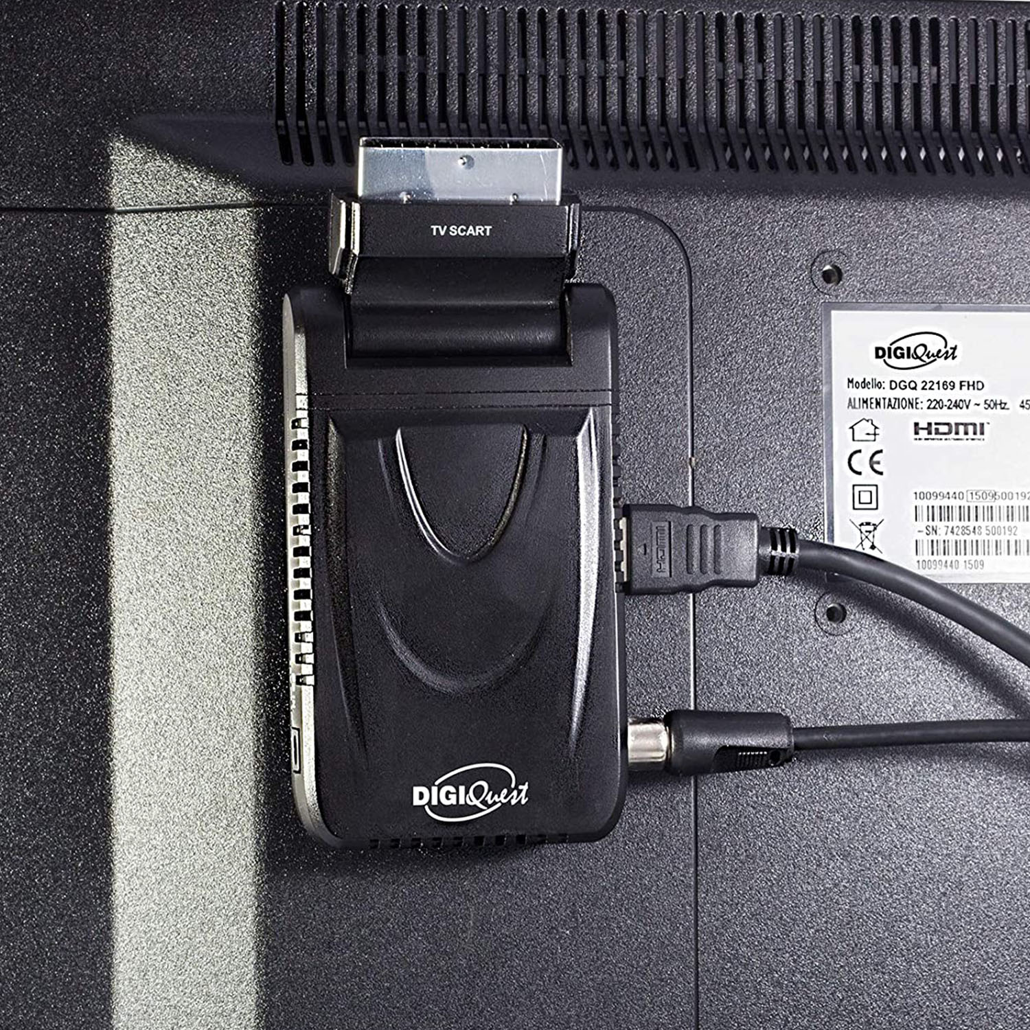 Retro di un televisore con adattatore DigiQuest collegato. Cavi HDMI e altri sono collegati. Sfondo nero.
