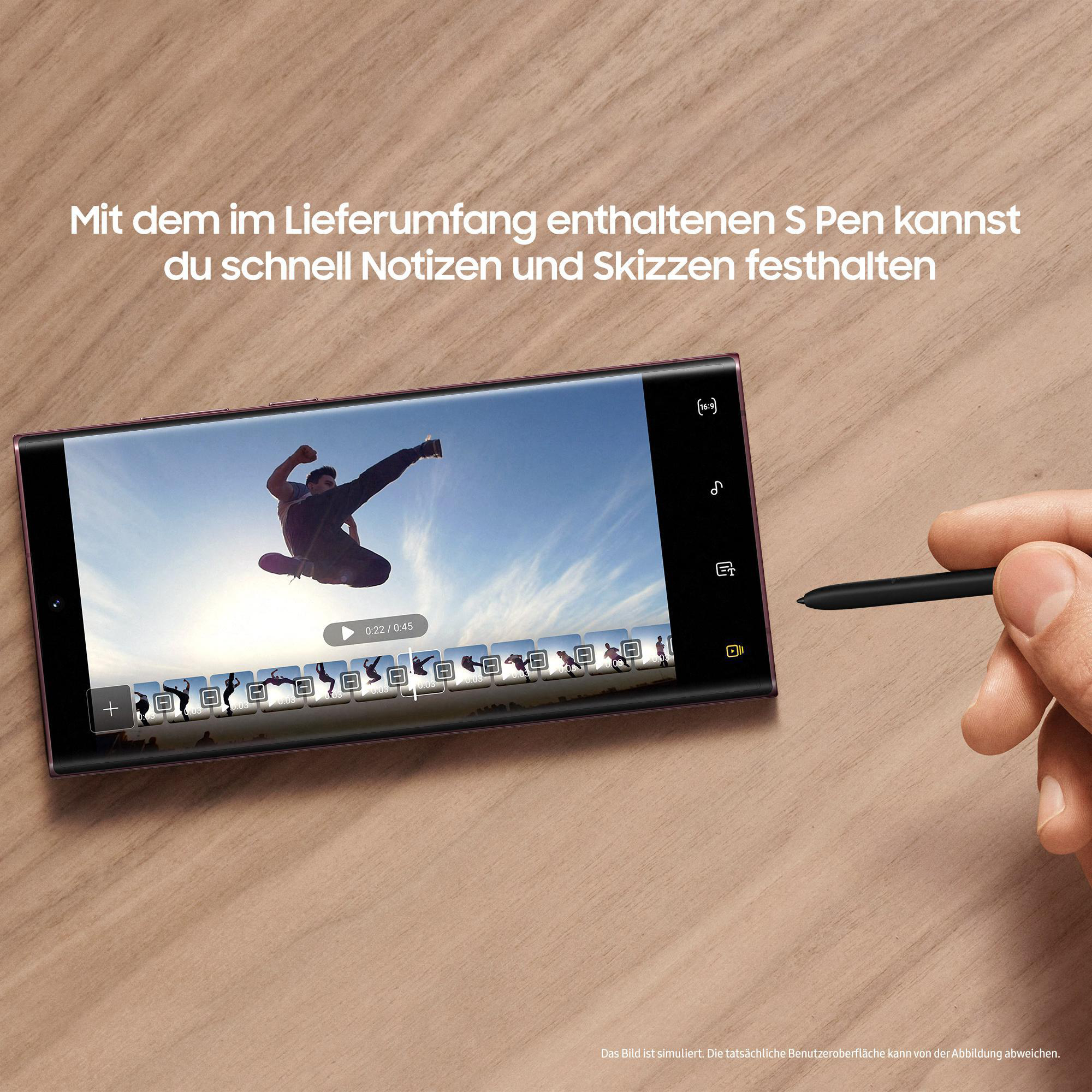 Eine Person, die ein Samsung-Telefon mit einem Stift verwendet. Auf dem Bildschirm des Telefons wird ein Video abgespielt.
