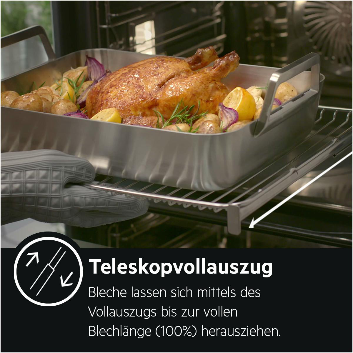Ein Brathähnchen mit Kartoffeln und Zitrone wird aus einem Ofen gezogen.