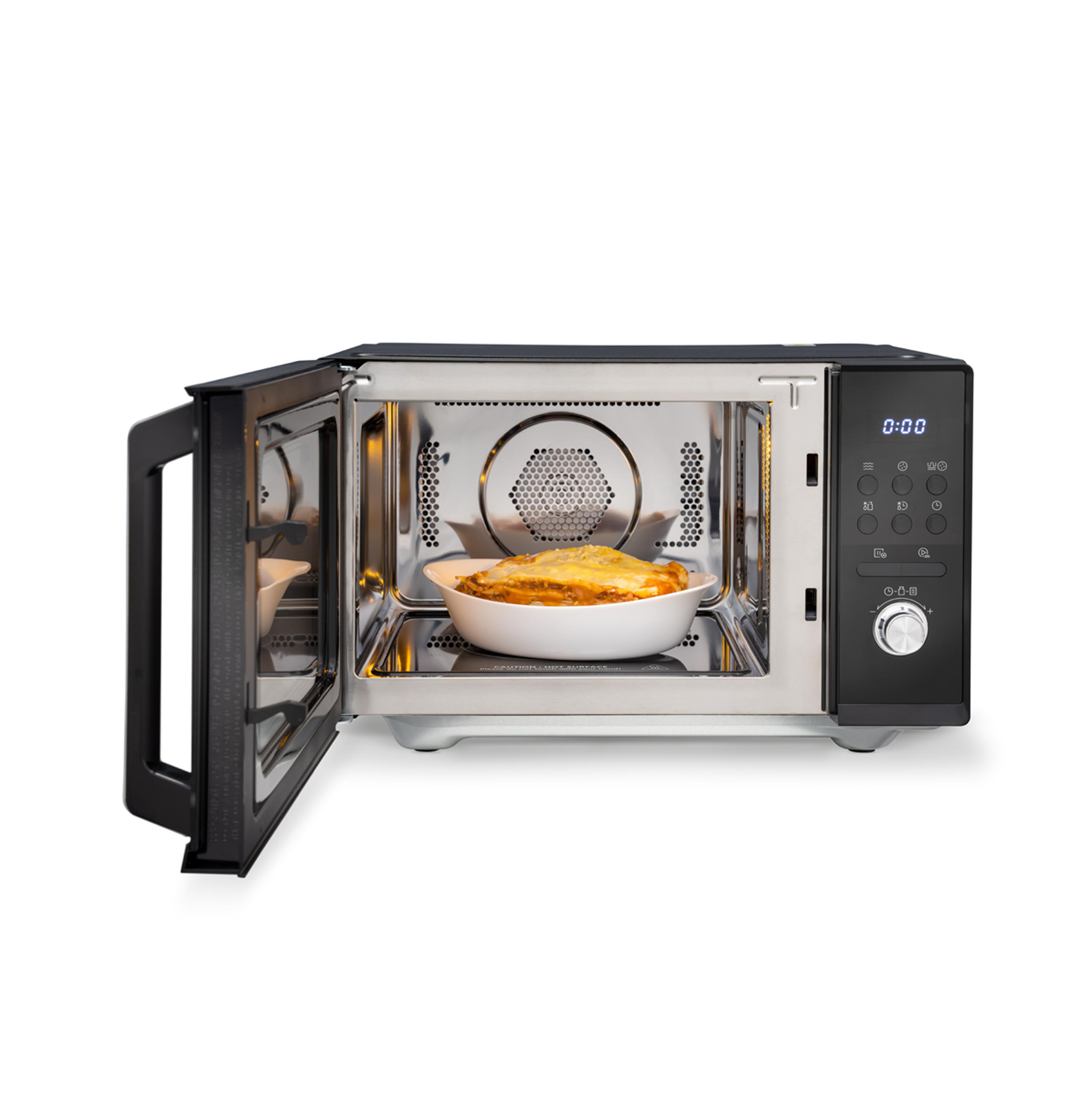 Mikrowelle mit offener Tür, ein Gericht mit Essen darin.