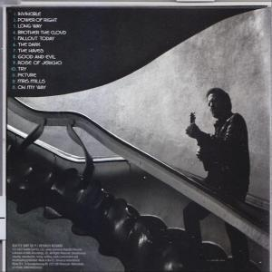 Ein Mann, der Gitarre spielt, während er auf einer Rolltreppe steht.