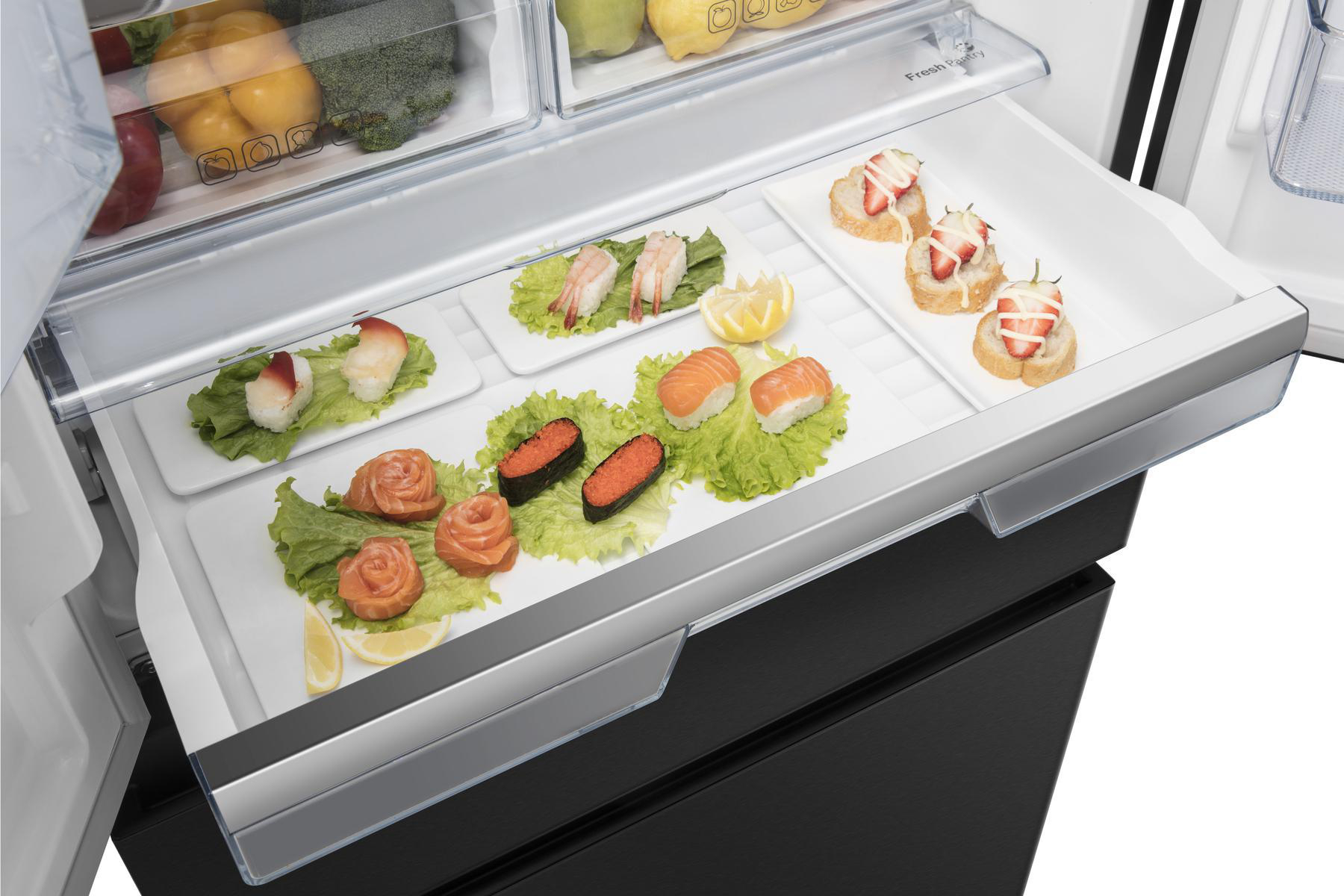 Offene Kühlschublade. Sushi, Vorspeisen und Zitronen auf Tellern. Obst und Gemüse im Hintergrund.