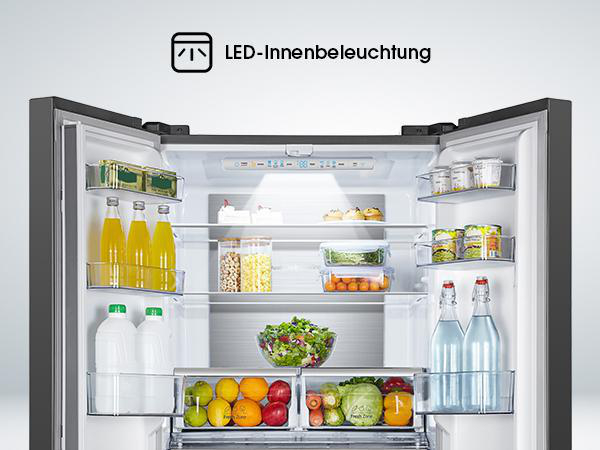 Geöffneter Kühlschrank mit Lebensmitteln auf Regalen, innen beleuchtet.