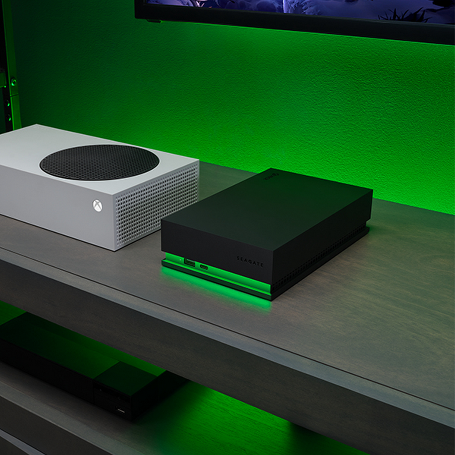 Una Xbox Series S blanca y un dispositivo de almacenamiento Seagate negro, con luces verdes.
