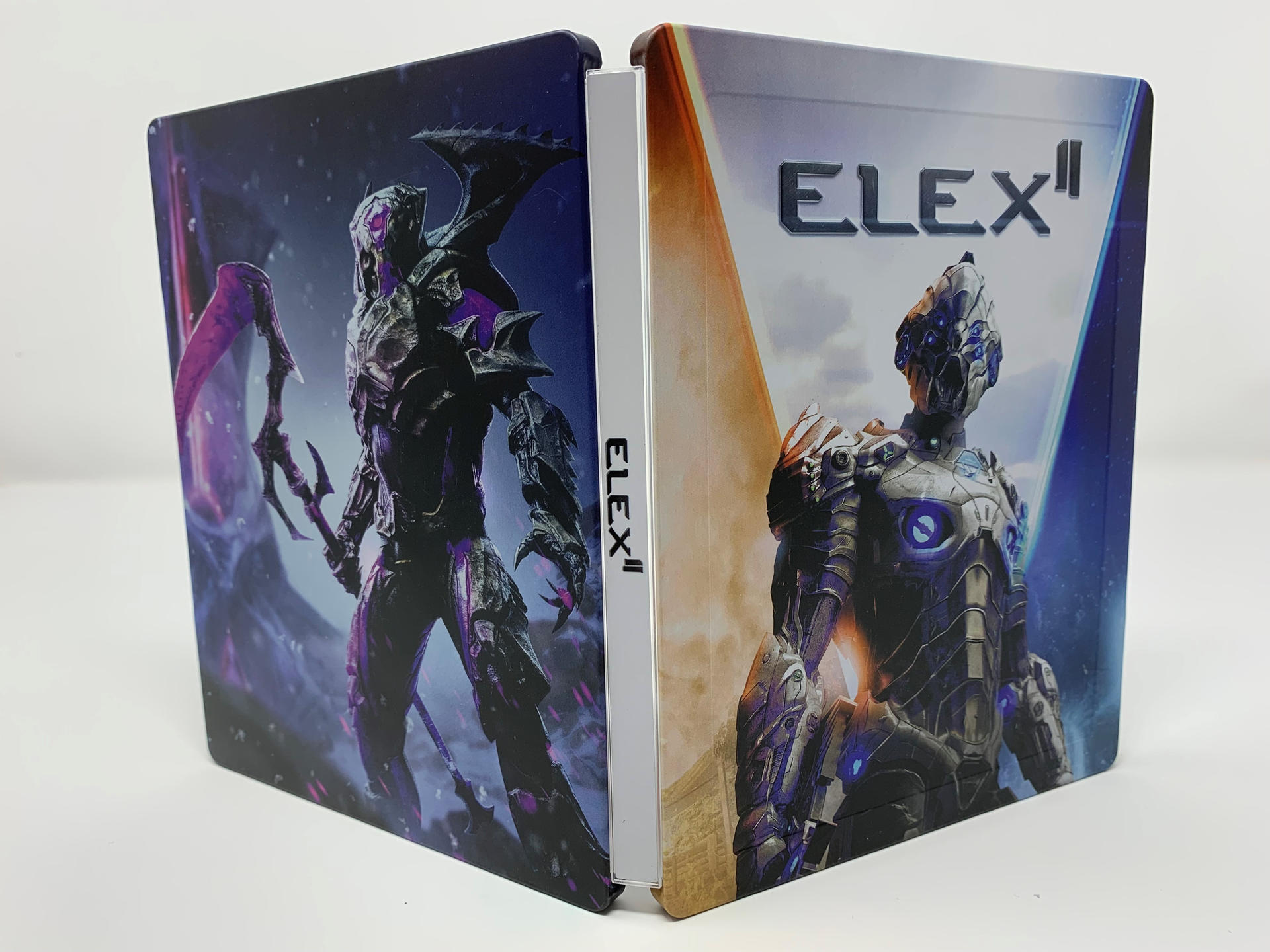 Eine Videospielhülle ist geöffnet und zeigt den Spieletitel 'ELEX II' auf dem Rücken und dem Cover.