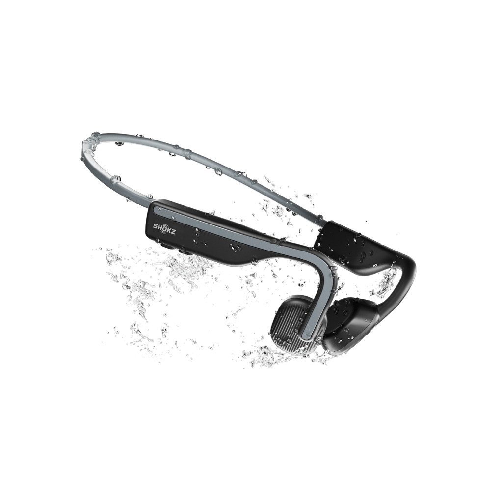 Schwarze und graue Shokz-Kopfhörer. Wasserspritzeffekt. Schwarzer Hintergrund. Knochenleitungskopfhörer.