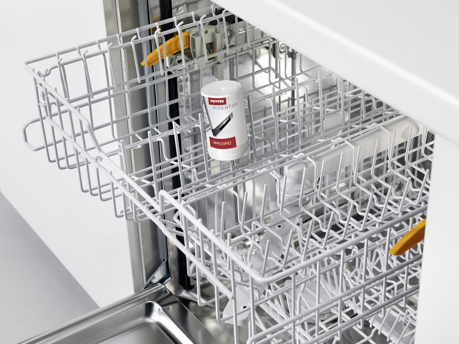 Een vaatwasserrek met een reinigingsproduct en schoon keukengerei.