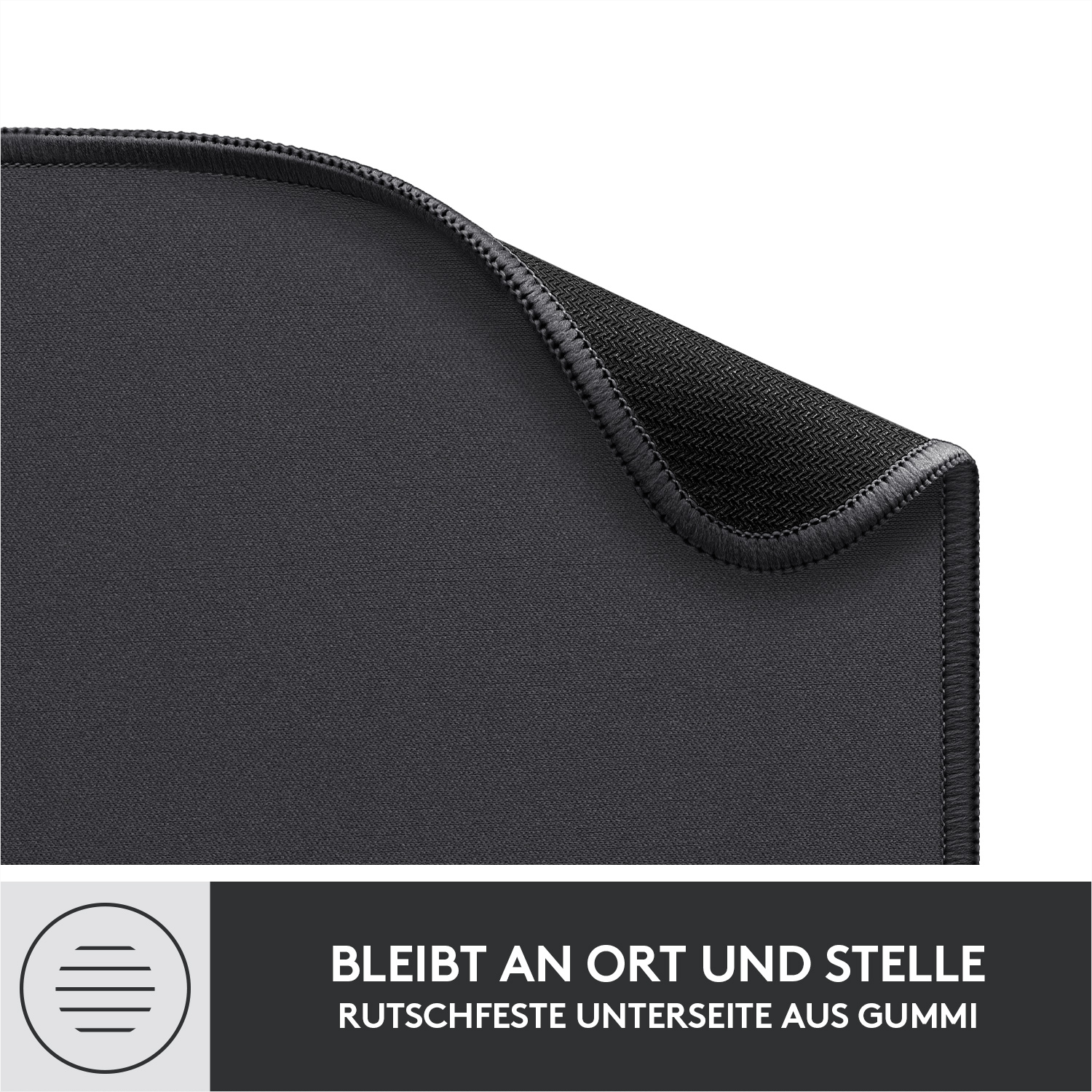 Nahaufnahme eines schwarzen Mauspads mit genähten Kanten und gummierter Unterseite. Text: 'BLEIBT AN ORT'.