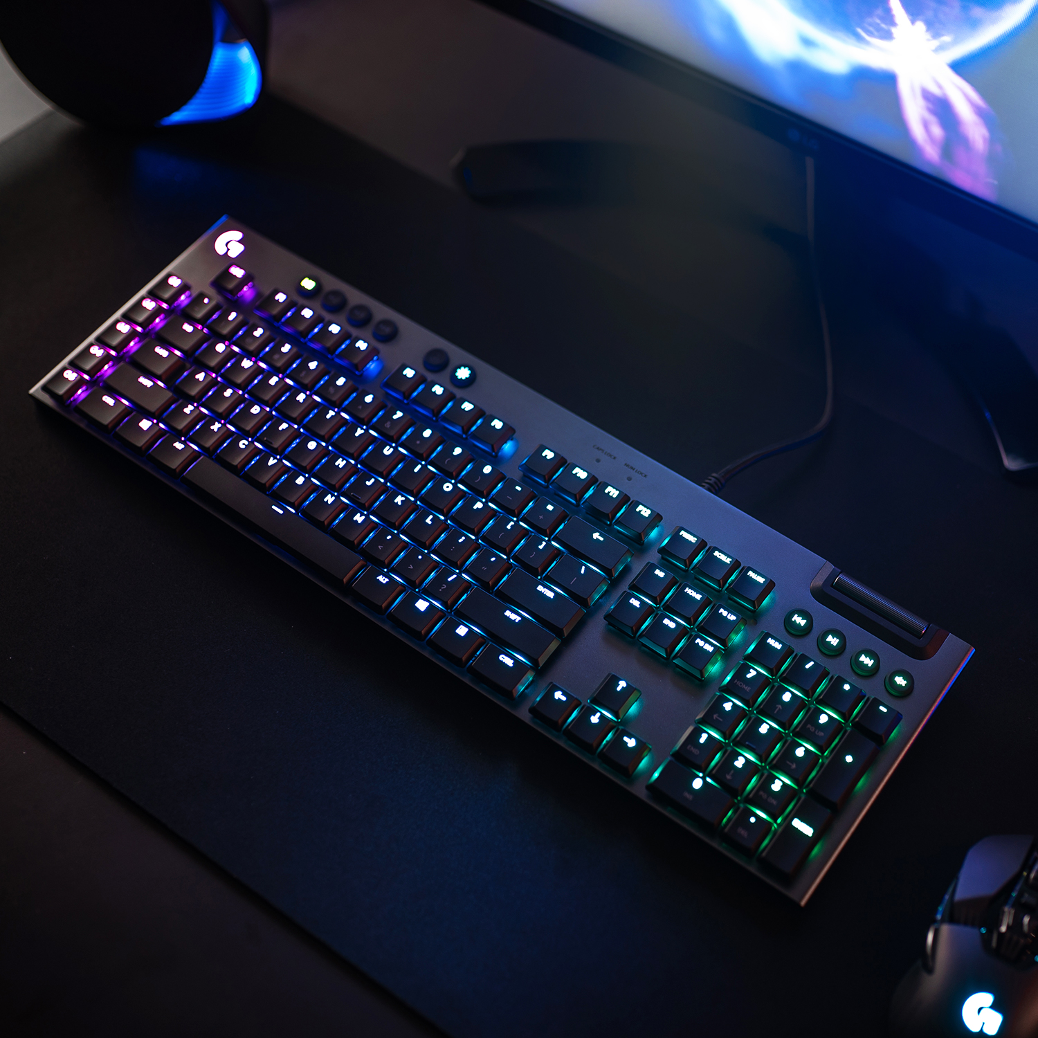 Un clavier noir avec des touches éclairées sur une surface noire. Le clavier est sur un bureau.