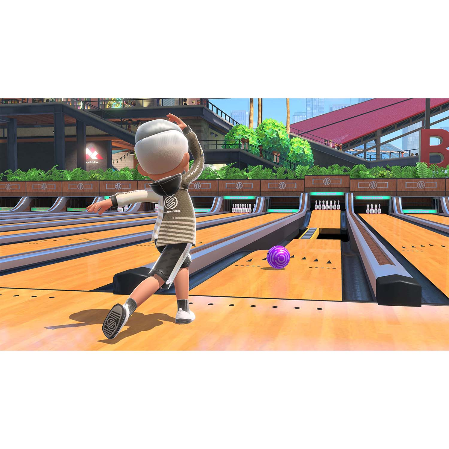 Una persona che gioca a bowling, che si prepara a lanciare una palla viola.