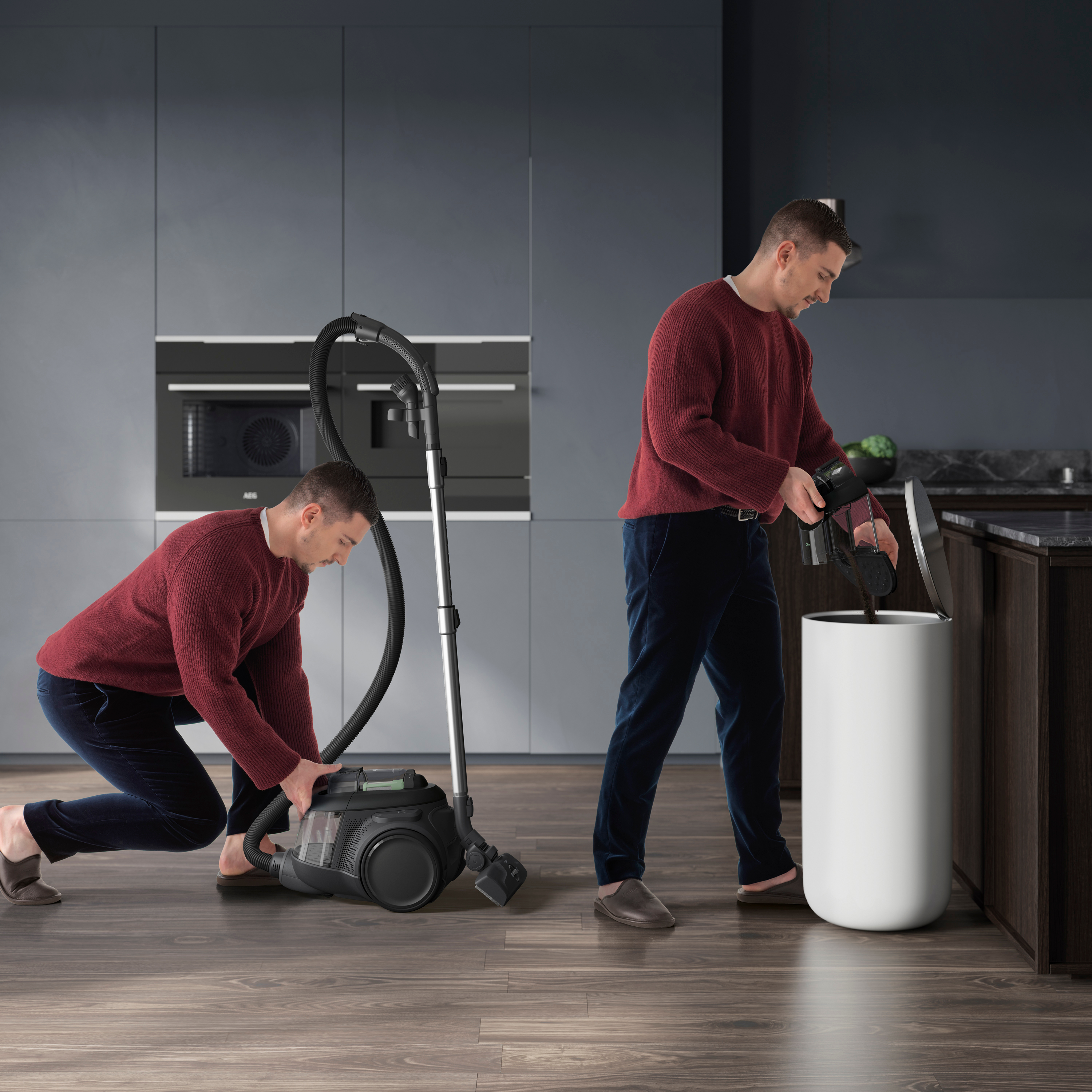 Zwei Männer, einer saugt, der andere leert einen Mülleimer mit angeschlossenem Staubsauger.