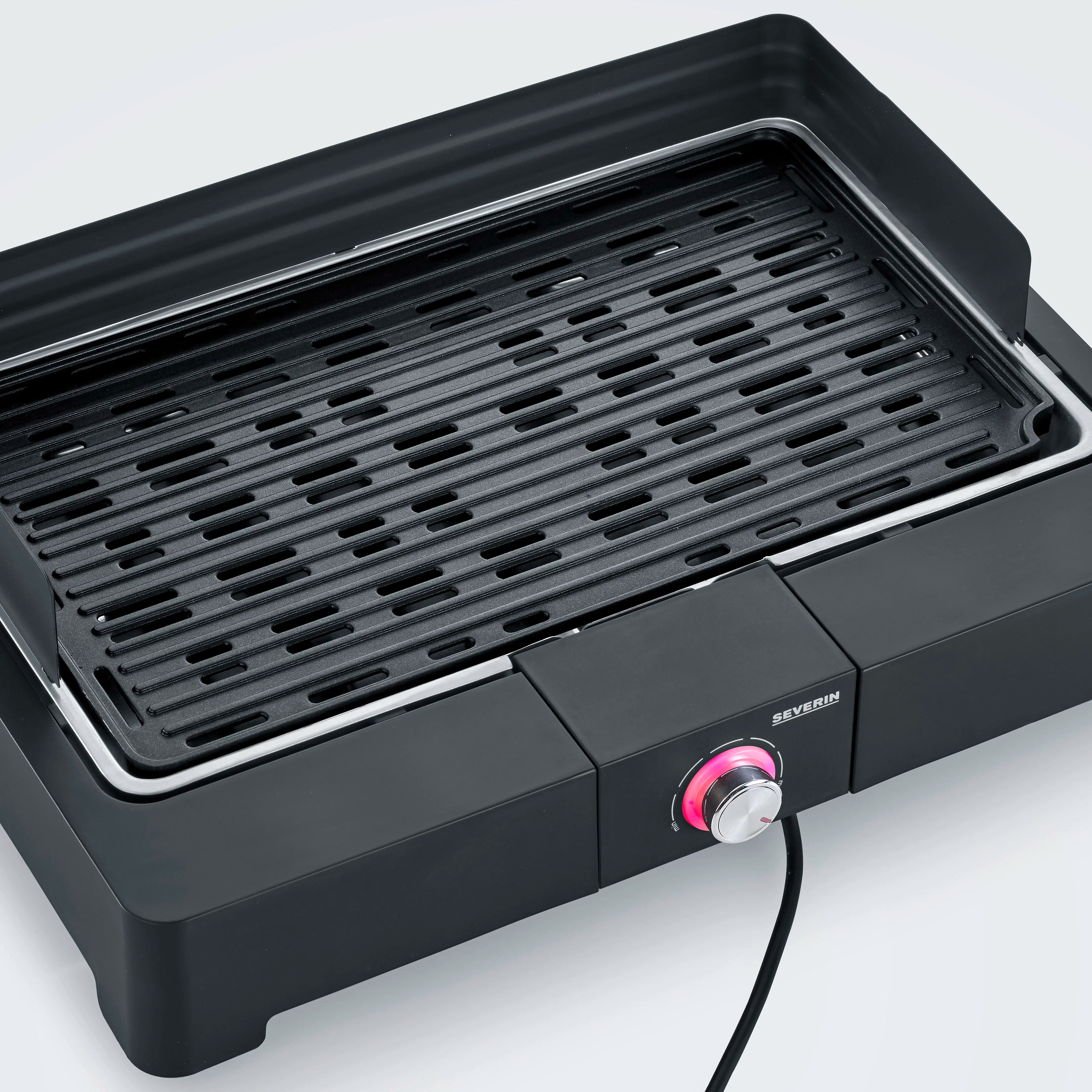 Ein schwarzer Elektrogrill mit rotem Drehknopf und Heizelement.