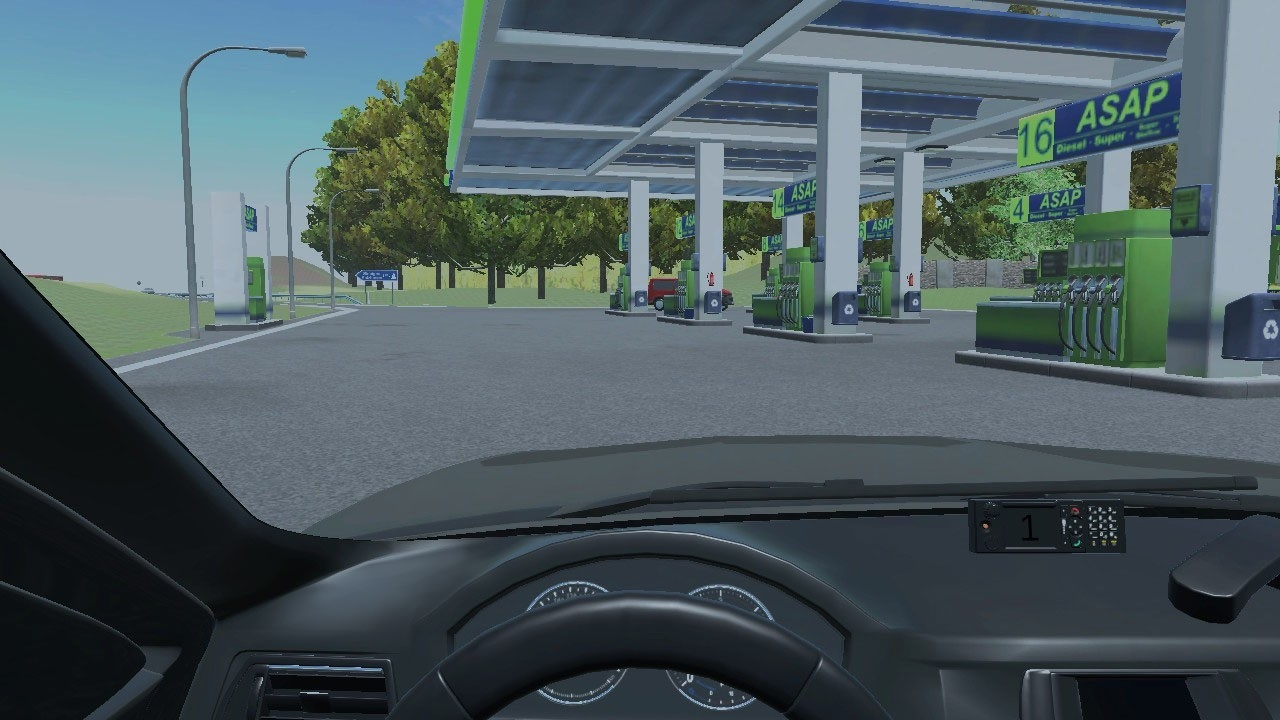 Vue de l'intérieur d'une voiture vers une station-service avec pompes et ciel bleu.