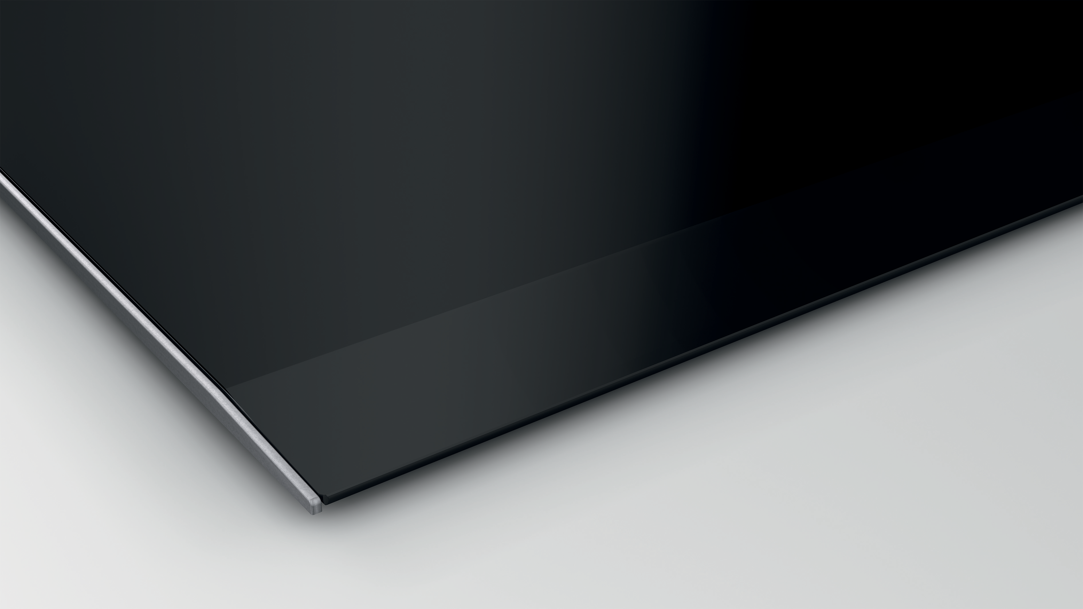 Surface en verre noir avec bord argenté. Fond blanc. Vue rapprochée.
