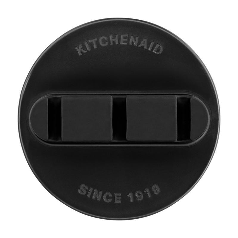 Schwarzes Kitchenaid-Logo auf schwarzer kreisförmiger Oberfläche. Text: Kitchenaid Since 1919.