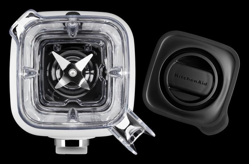 Mixer-Teile: klarer Behälter, Deckel mit KitchenAid-Logo und sichtbare Klingen.