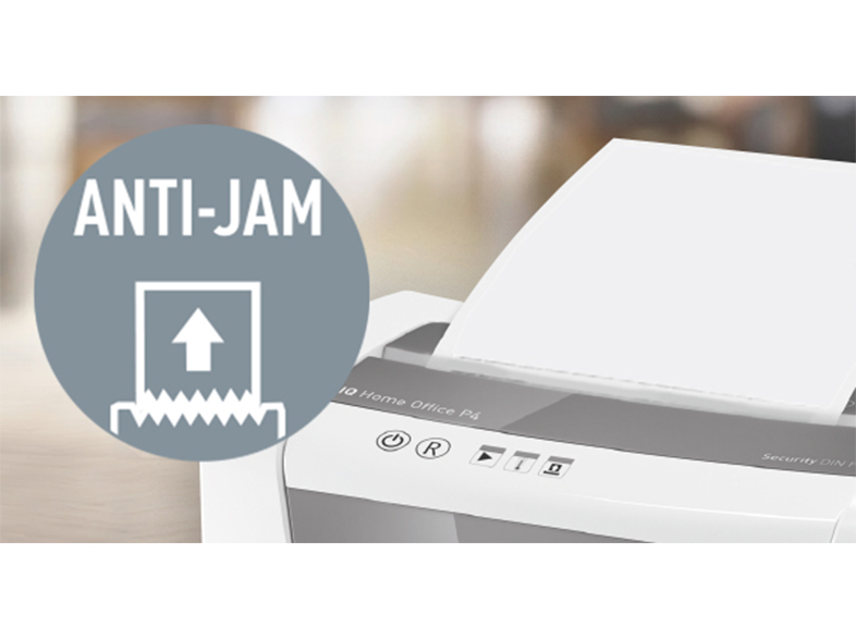 Egy iratmegsemmisítő, amelybe papírt adagolnak. Egy körben a 'ANTI-JAM' felirat látható balra.