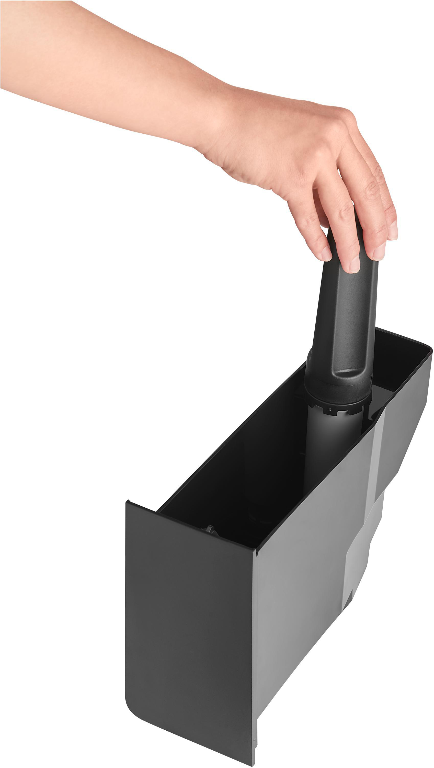 Hand setzt schwarzen Filter in schwarzen Wasserfilterbehälter ein.