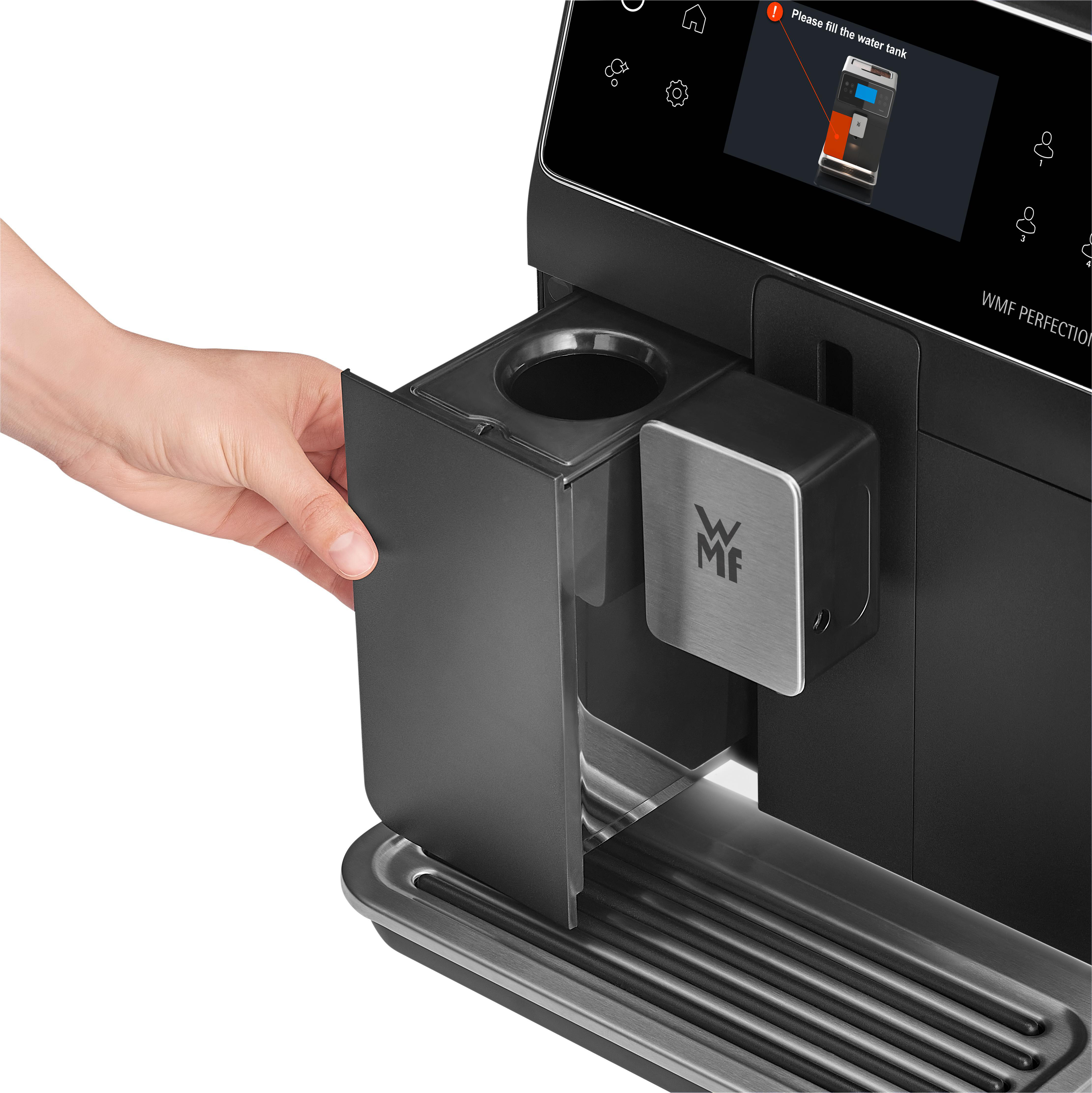 Schwarze Kaffeemaschine mit Hand, die einen Behälter öffnet, und Bildschirm.