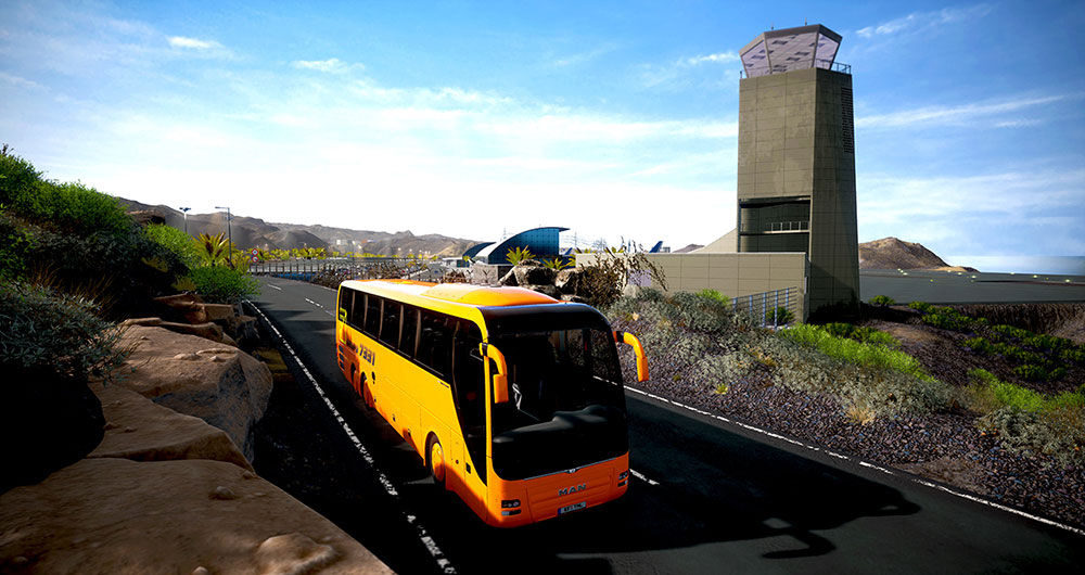 Autobus giallo su una strada, torre di controllo dell'aeroporto sullo sfondo. Cielo blu chiaro e piante verdi.