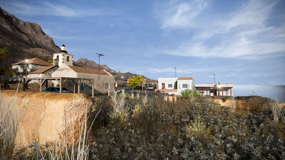 Villaggio costiero con edifici bianchi, una chiesa e montagne sullo sfondo, cielo blu.
