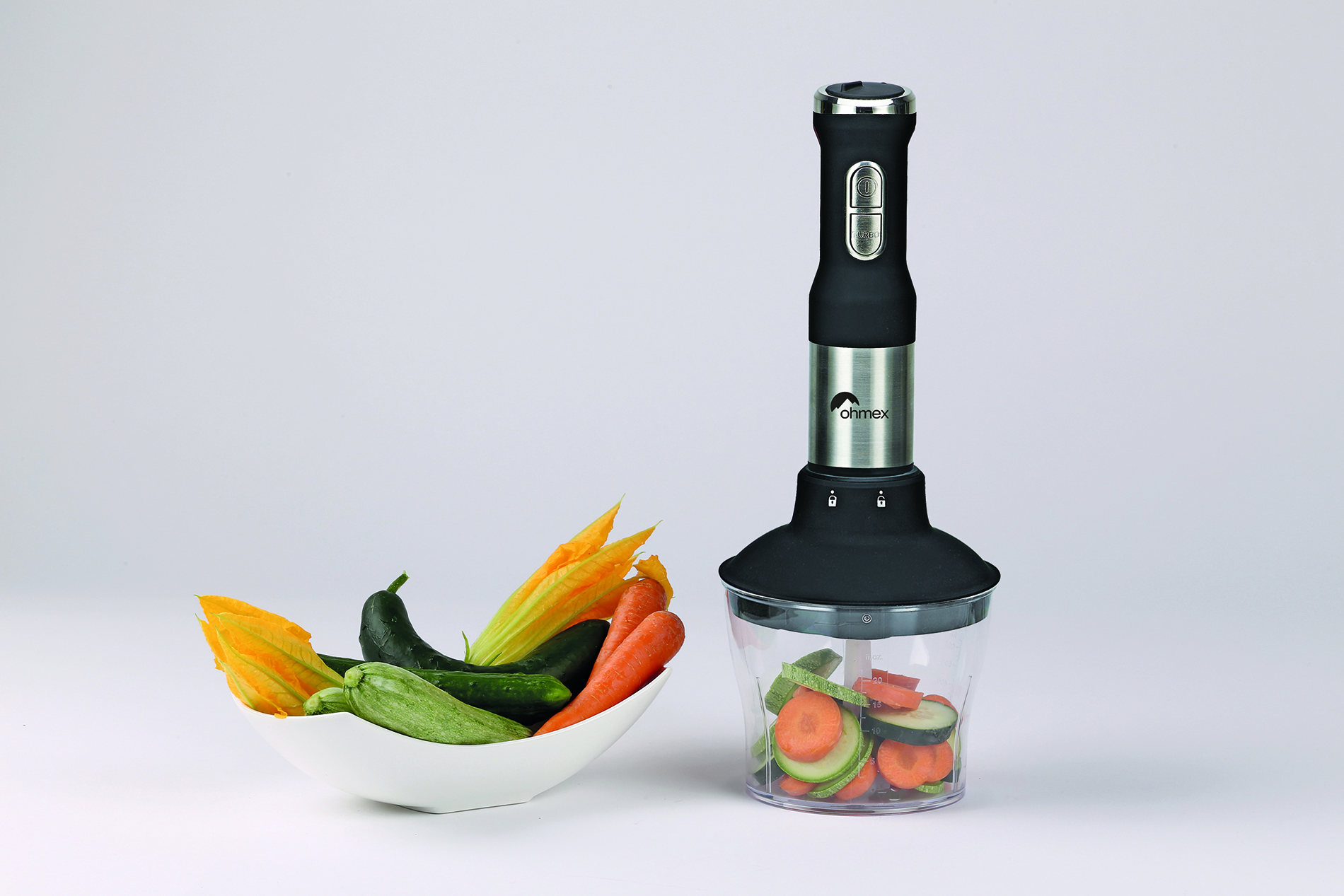 Un mixeur plongeant avec des légumes dans un bol.