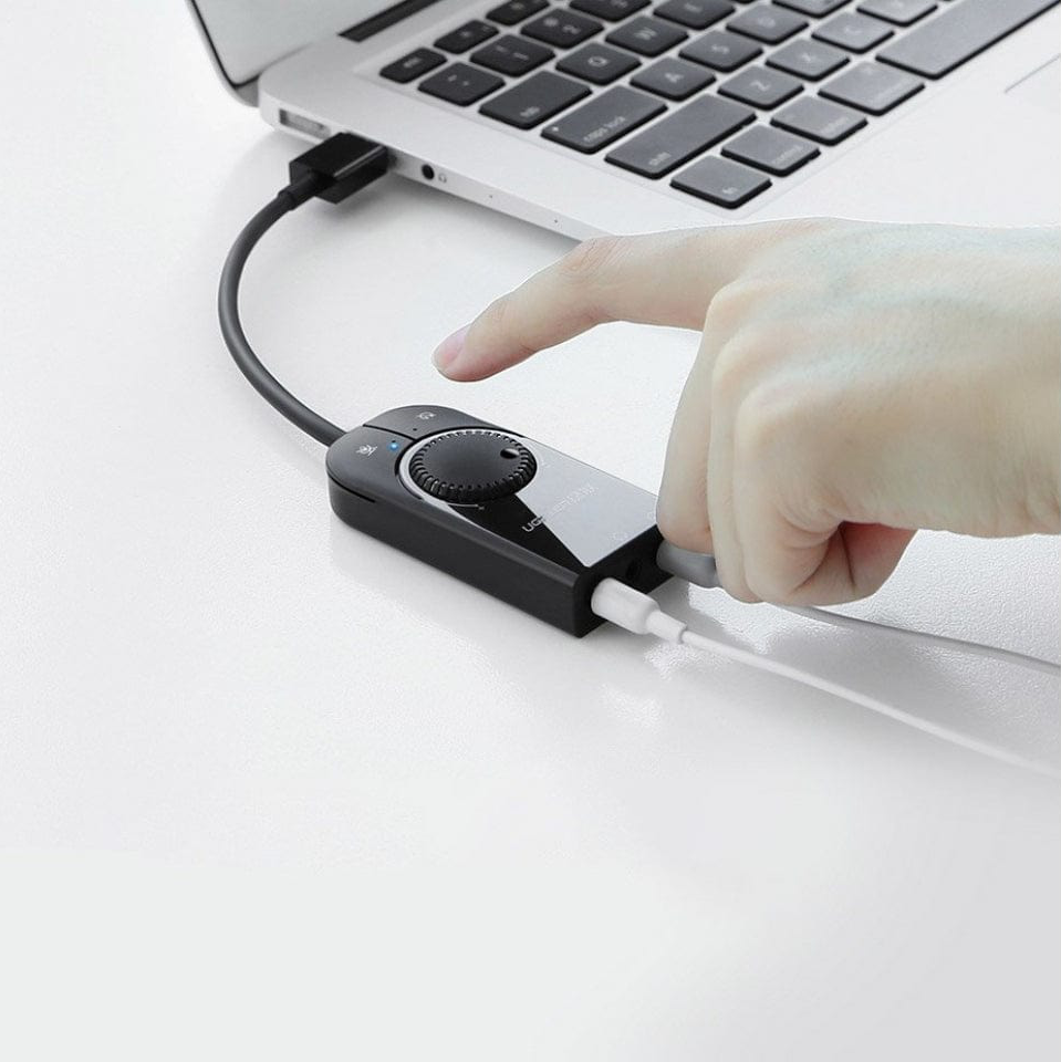 Una mano che utilizza un dispositivo collegato a un laptop. Il dispositivo ha una manopola e dei pulsanti.