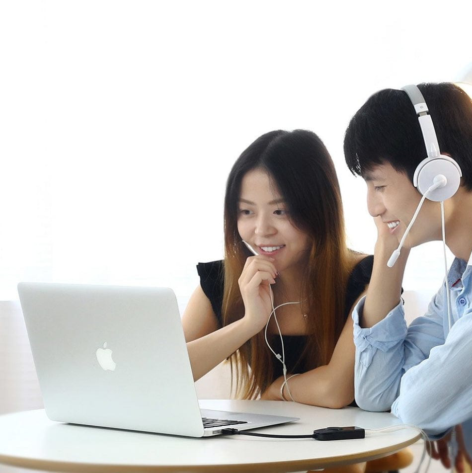 Due persone che usano un laptop con le cuffie.