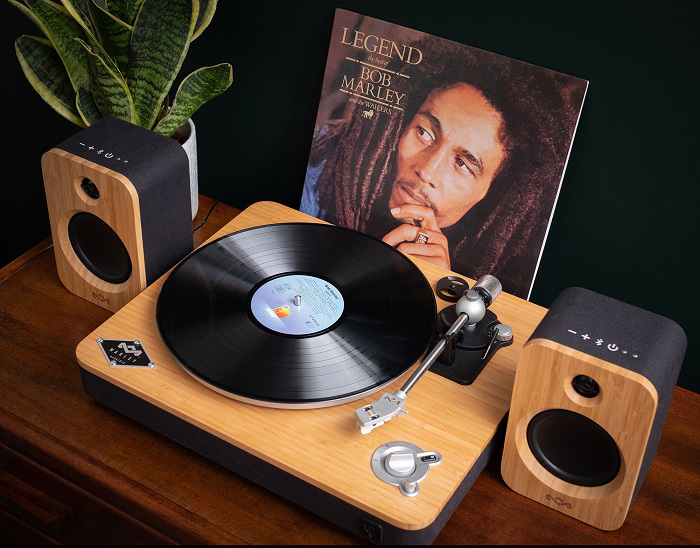 Lejátszó Bob Marley albummal és hangszórókkal fa felületen.