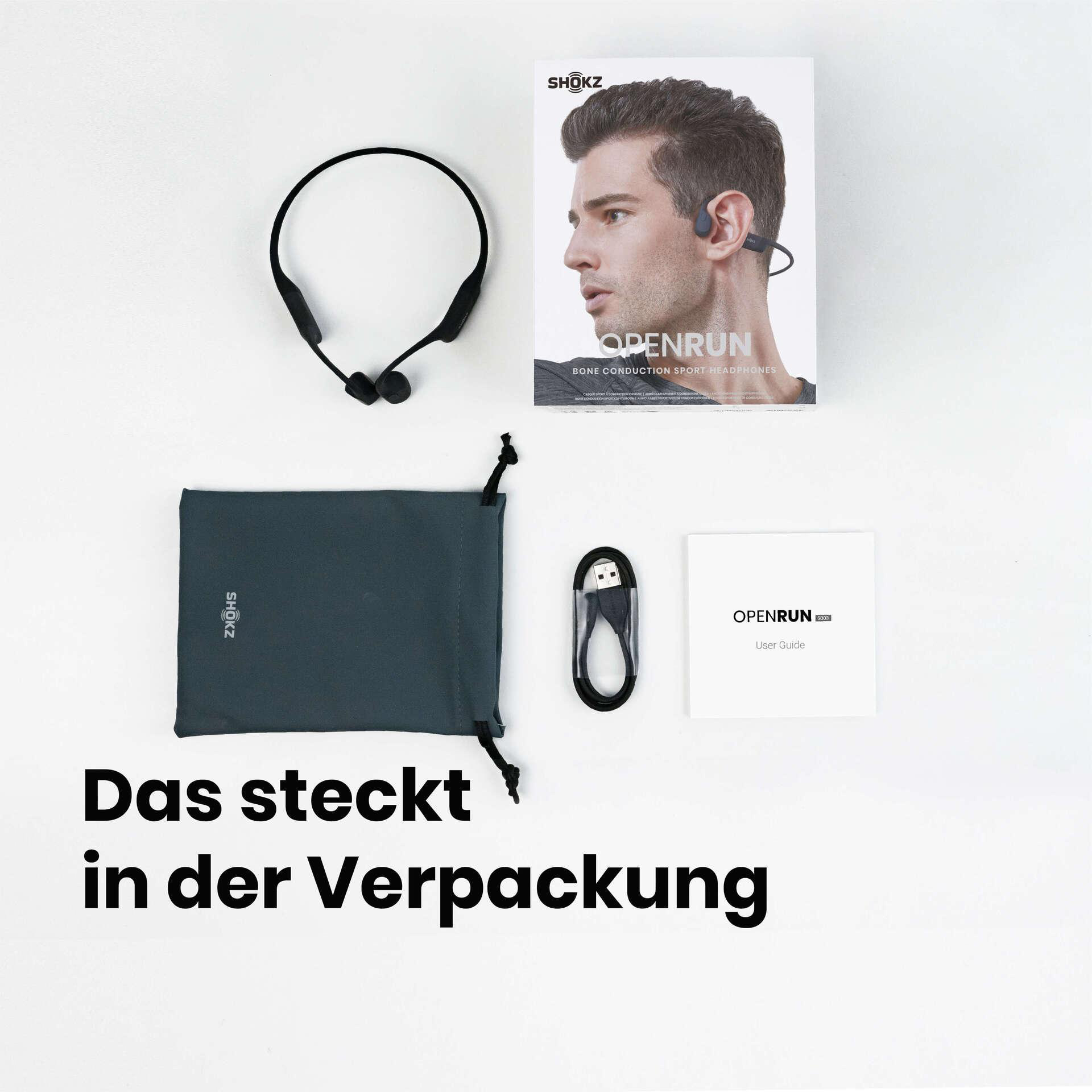 Das Bild zeigt den Inhalt der Shokz OpenRun-Kopfhörer-Verpackung: Kopfhörer, Tasche, Kabel, Benutzerhandbuch und Box.