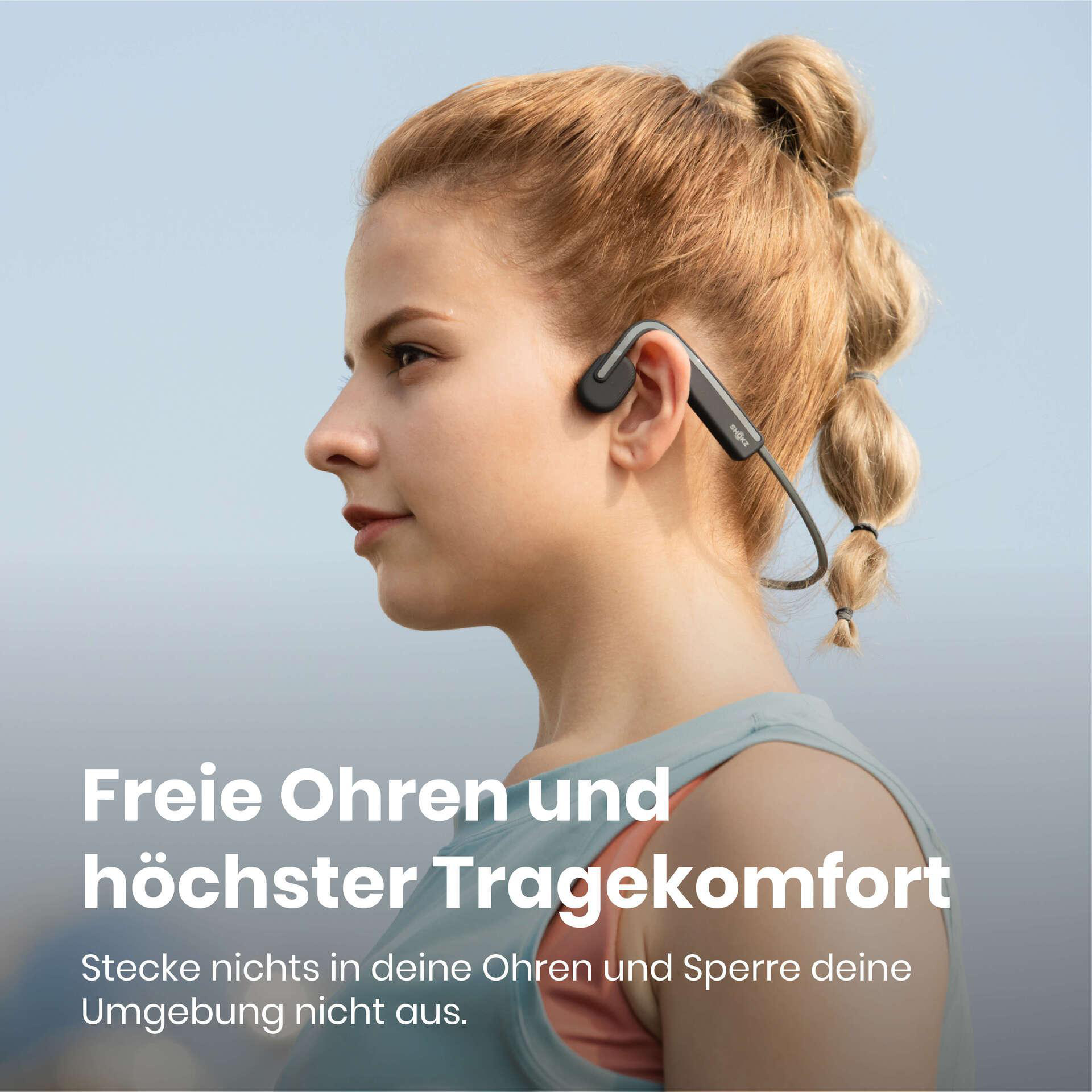 Eine Frau trägt Knochenleitungskopfhörer. Text lautet 'Freie Ohren und höchster Tragekomfort'.