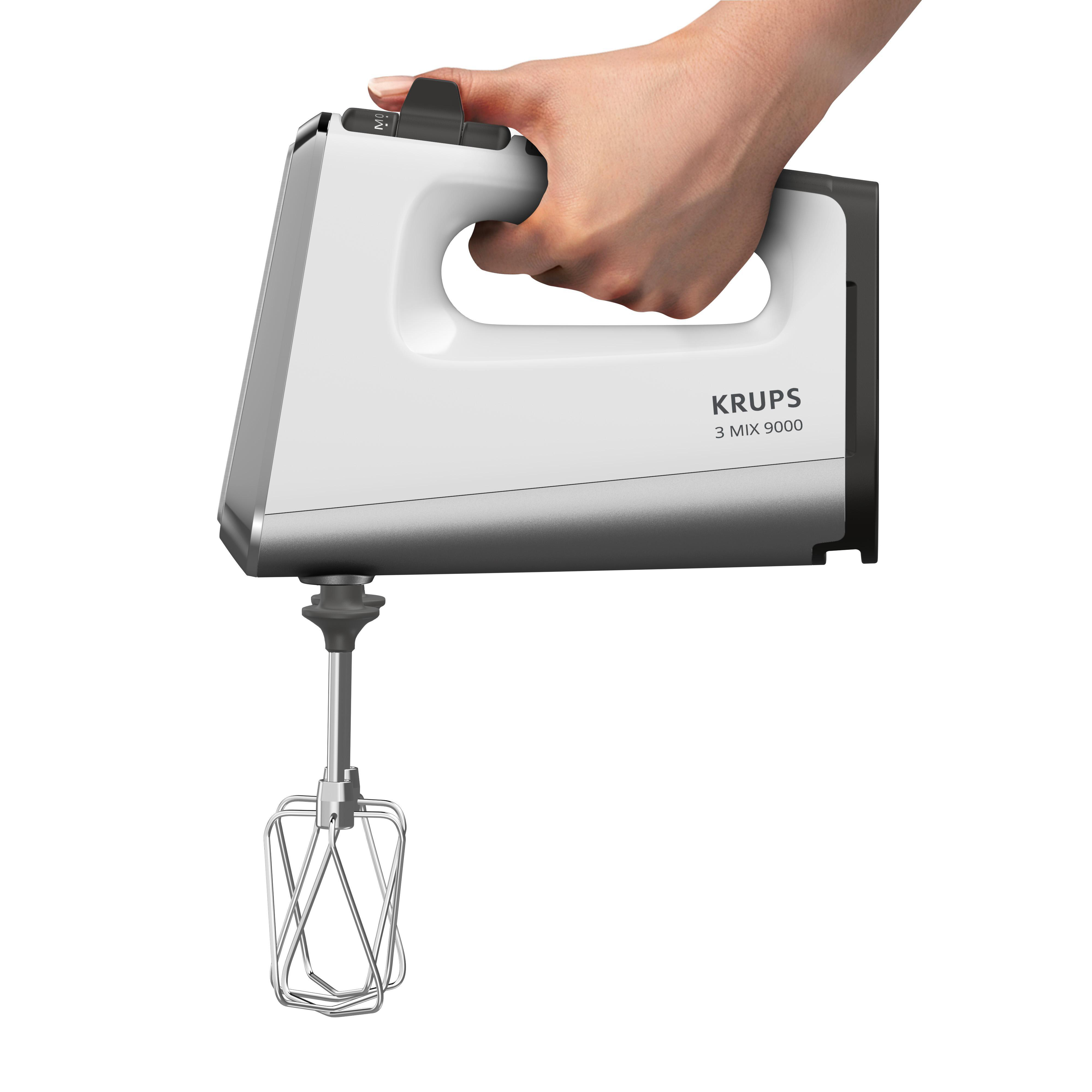 Hand, die einen weißen und silbernen Handmixer hält. Weißer Hintergrund.