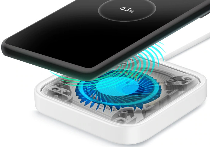 Phone charging wirelessly. Phone is black, charger is white. Displaying 63% charge.